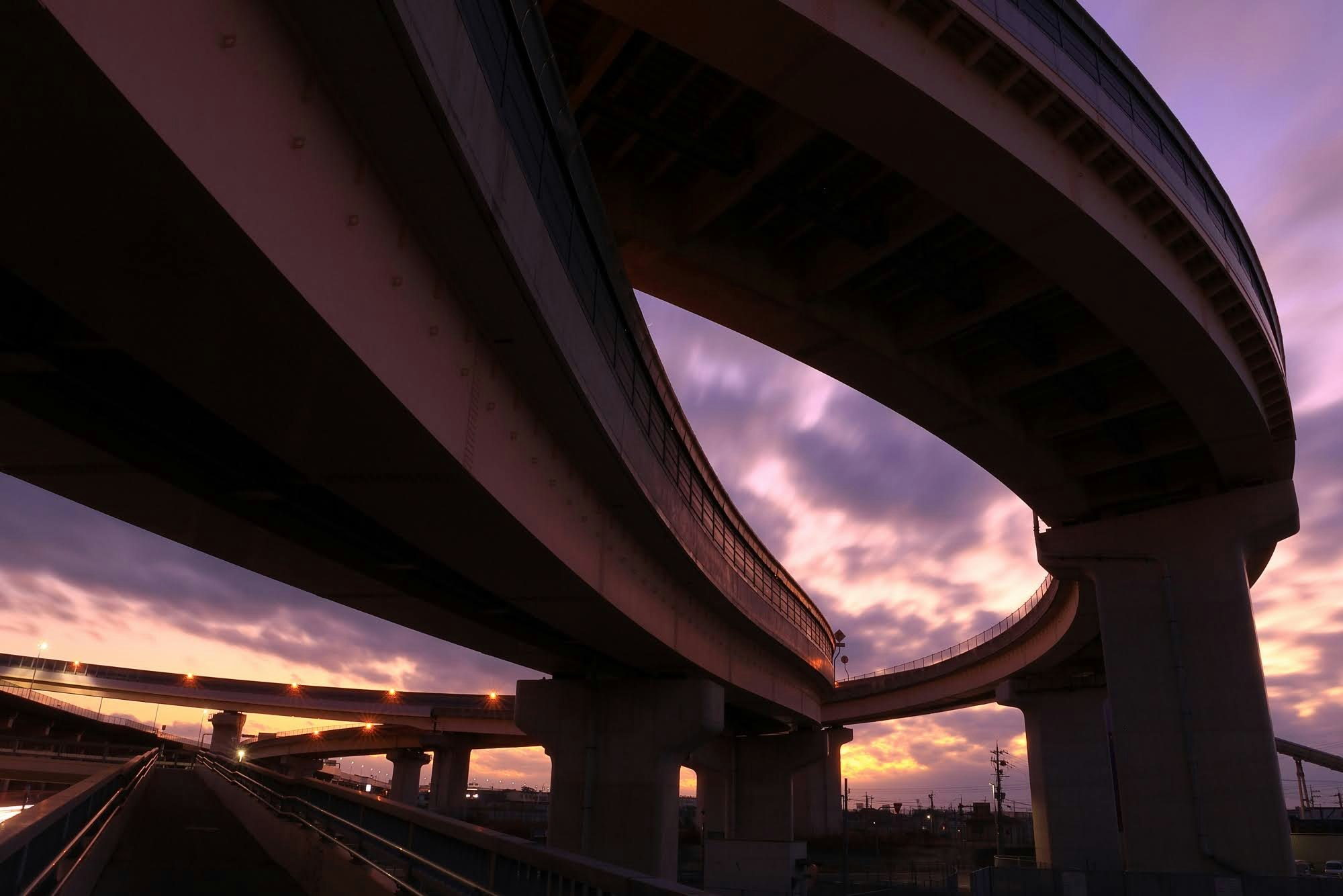 tramonto su un’autostrada sopraelevata e uno svincolo
