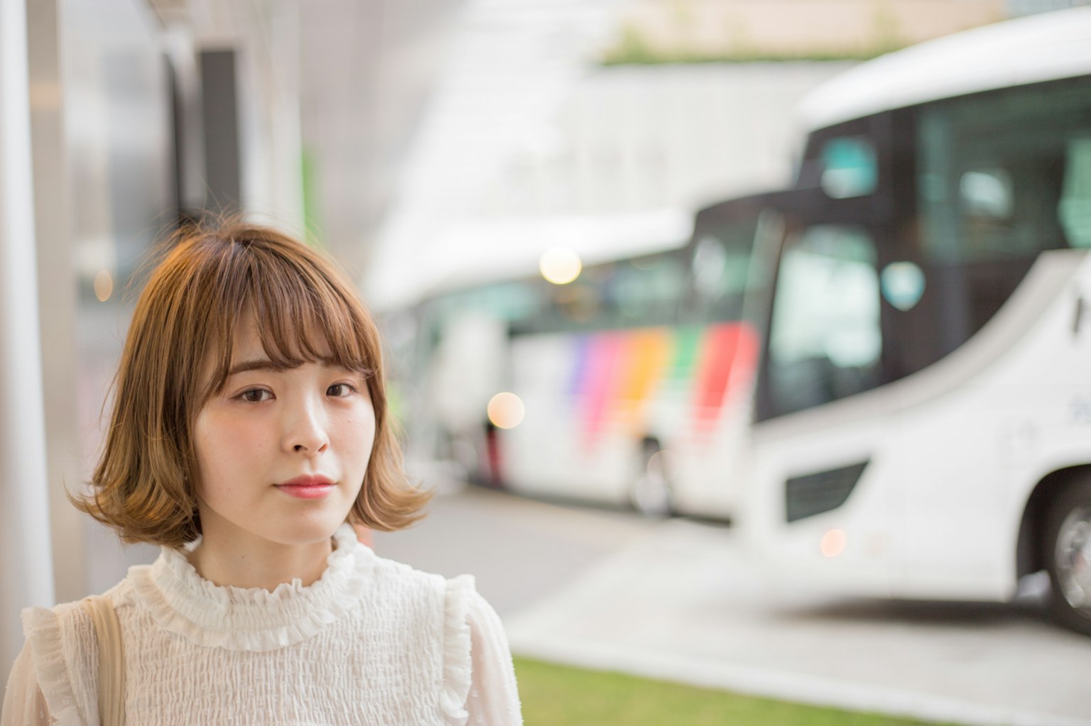 一名女性站在城市环境中的公交车附近