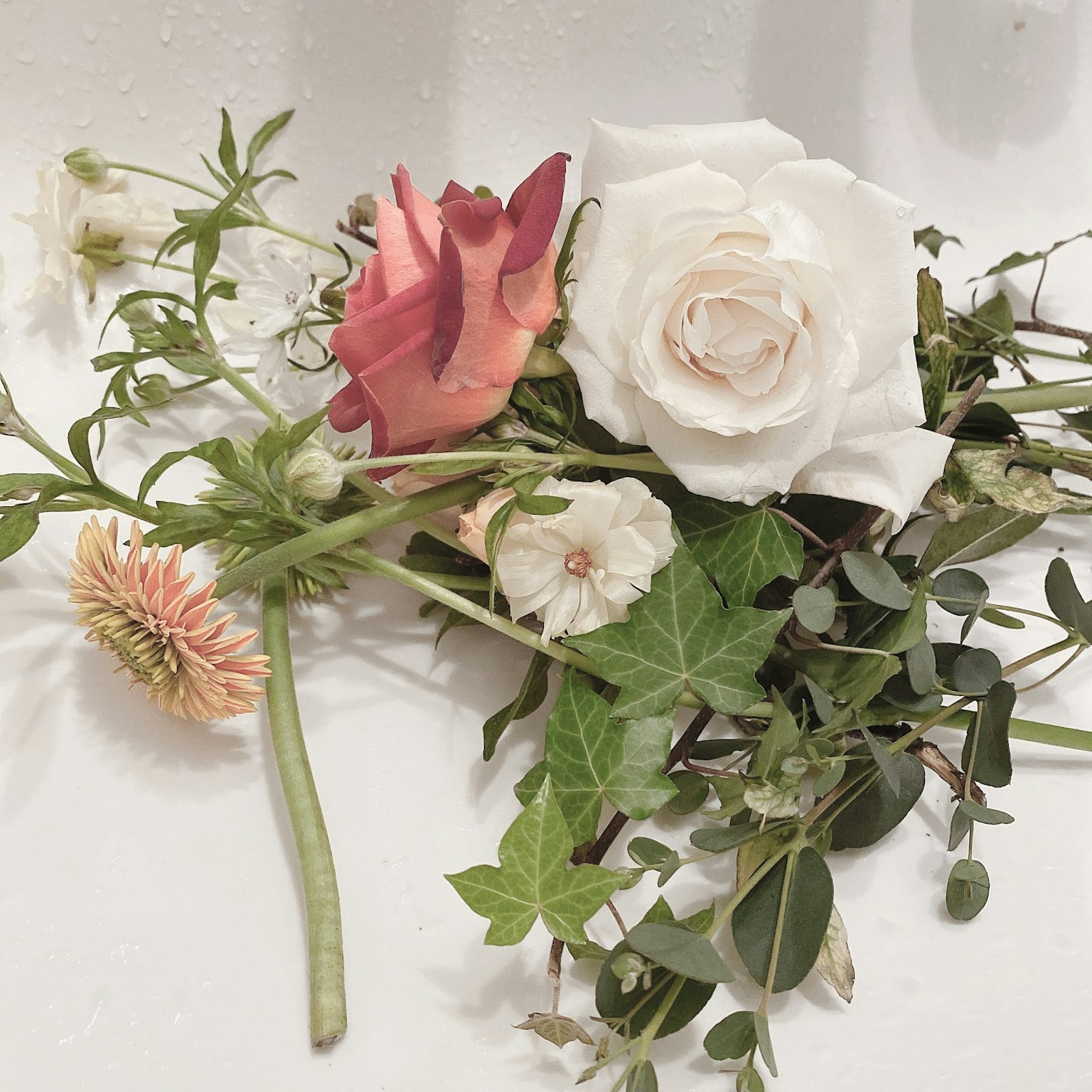 Composizione di fiori con una rosa bianca e una rosa rosa