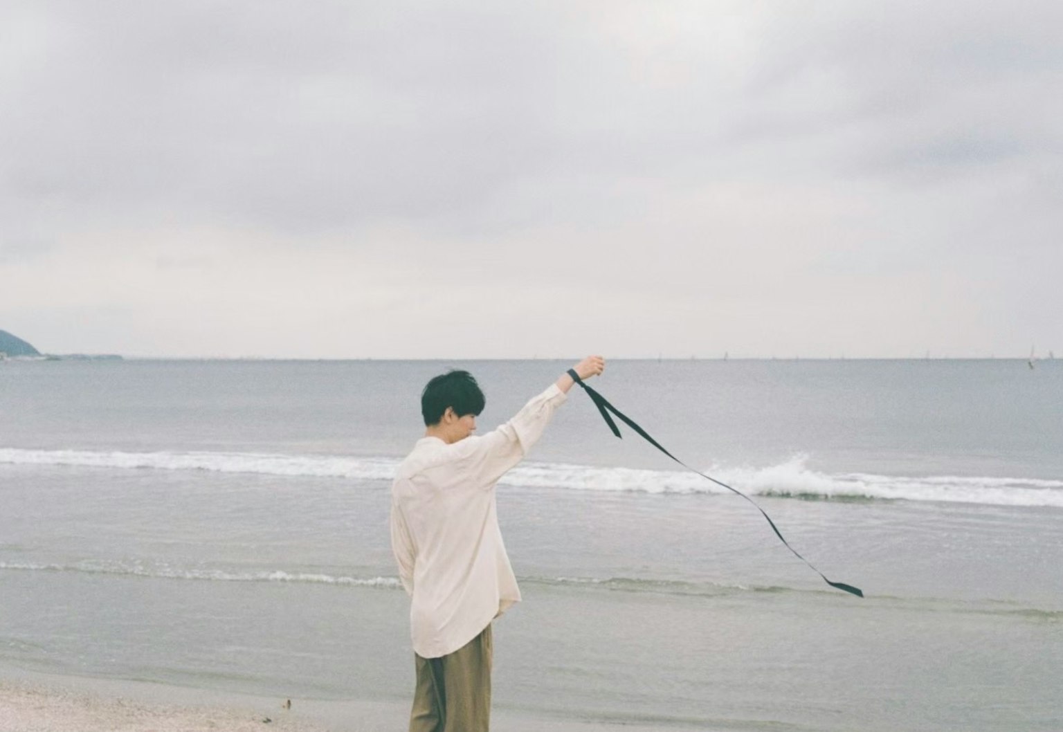 海邊拿著絲帶的男人