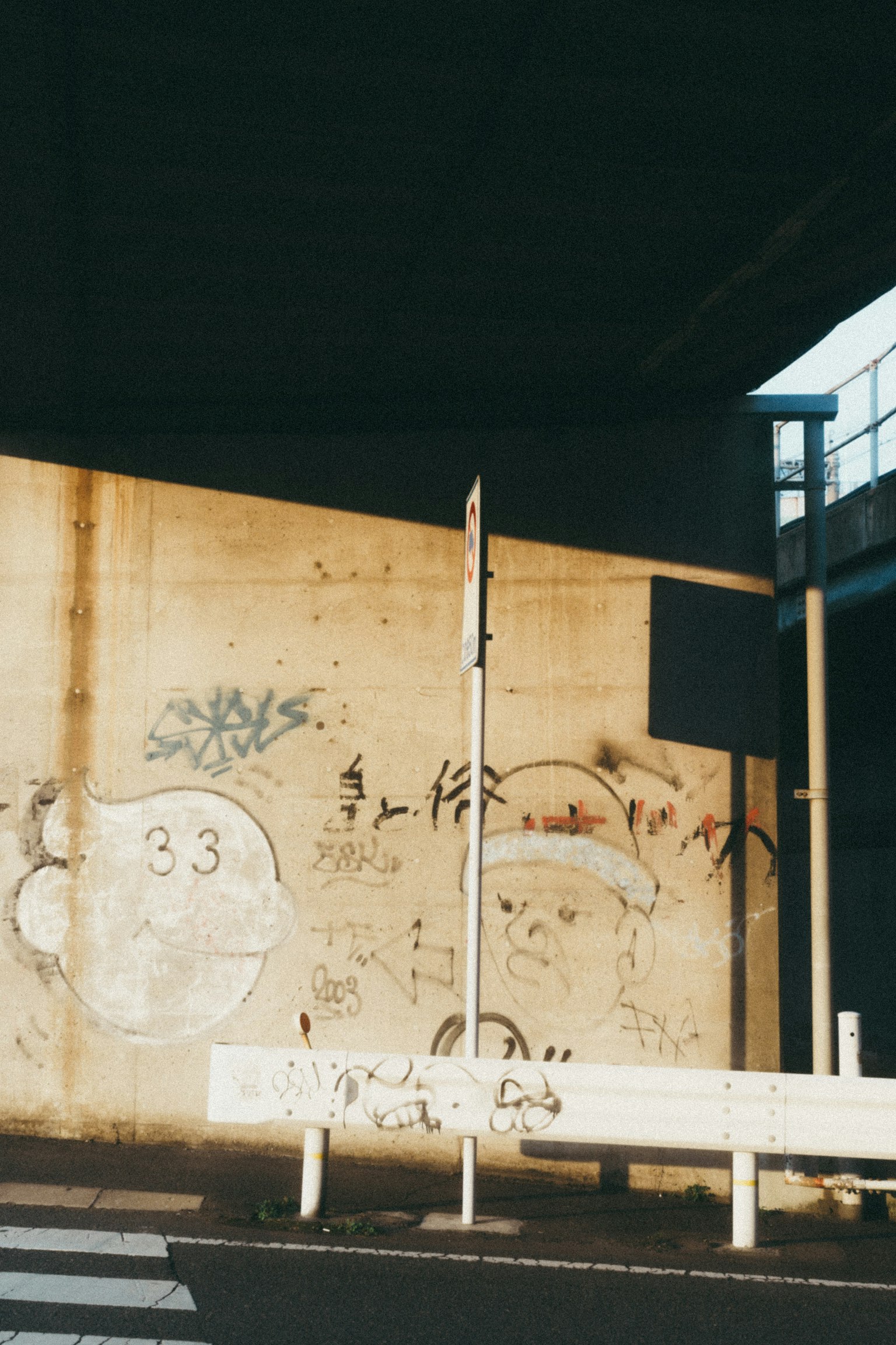 Cảnh đô thị với tường bê tông có graffiti và biển báo giao thông