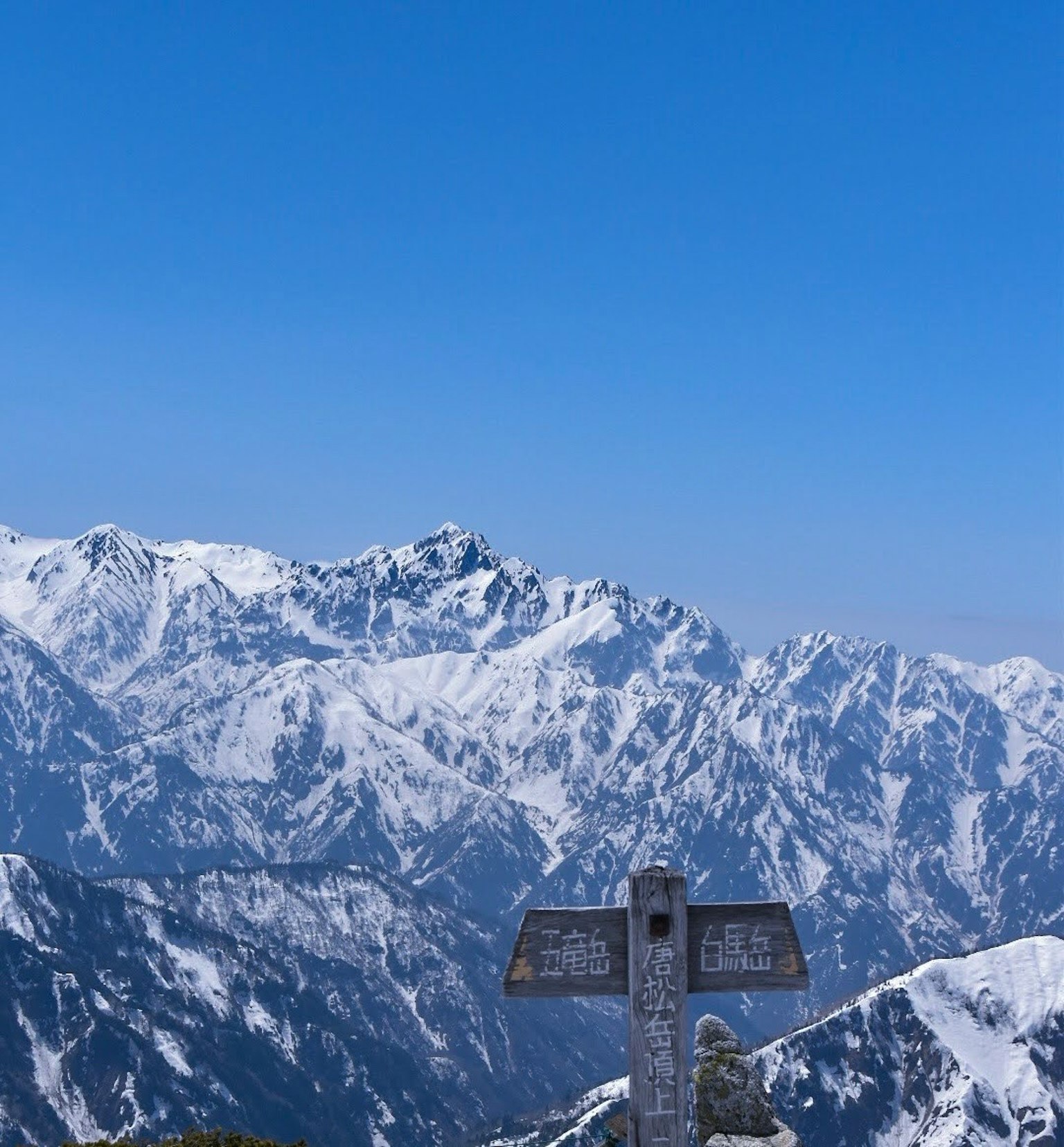 Vista escénica de montañas cubiertas de nieve con un cartel en primer plano