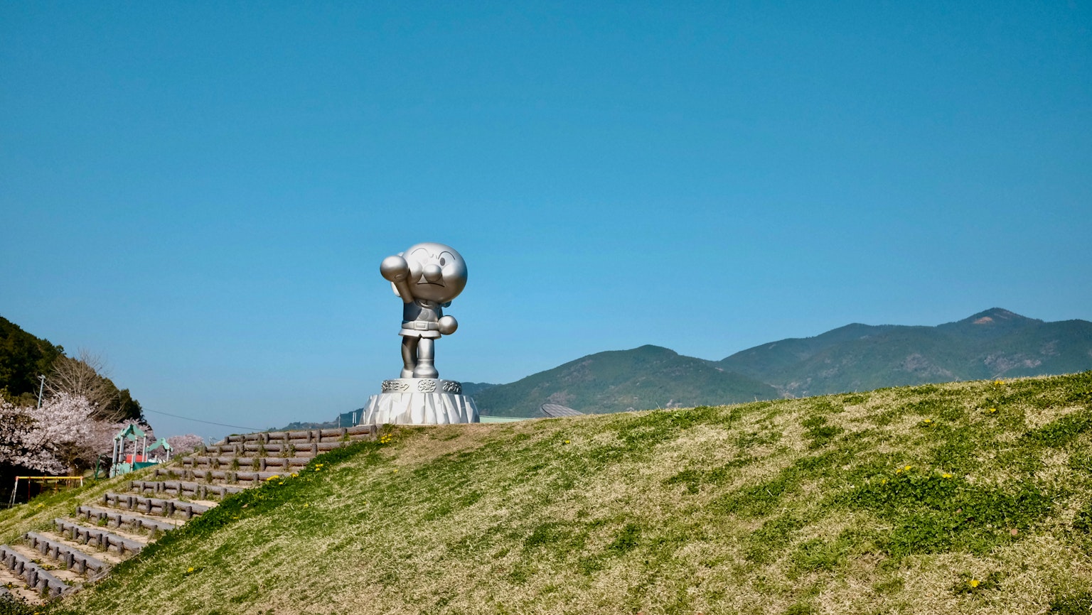 Skulptur unter einem blauen Himmel mit grünem Gras darum