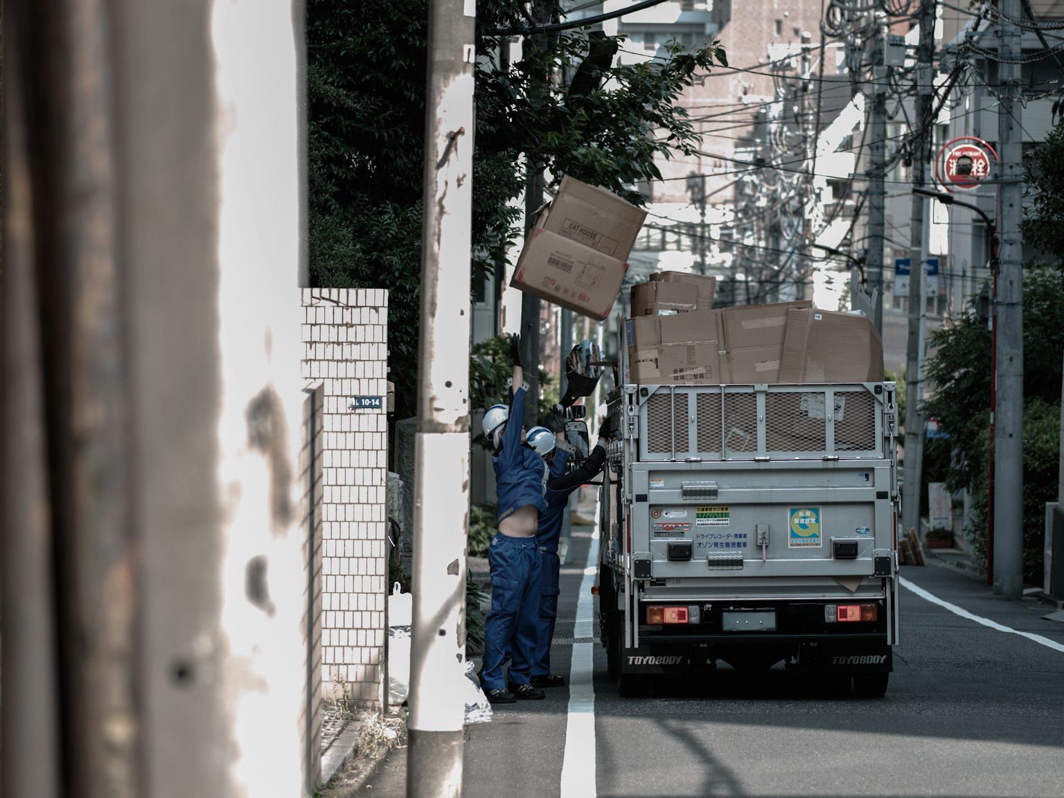 兩名工人在城市背景下將箱子裝入卡車