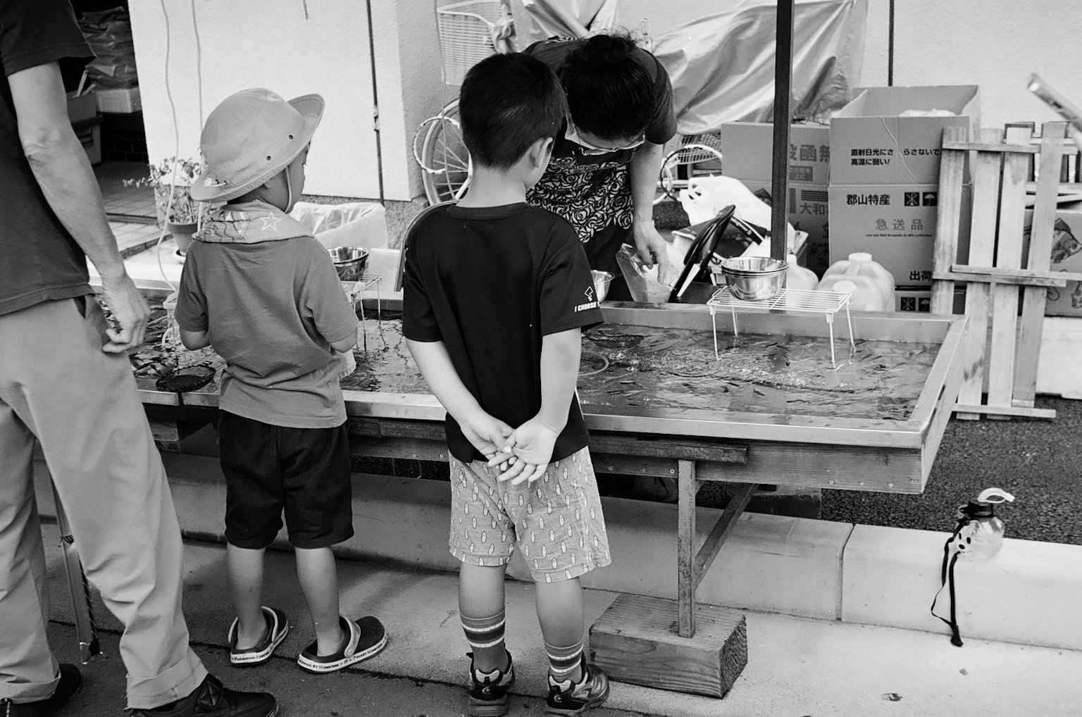 Trẻ em quan sát một người bán hàng tại quầy hàng đường phố