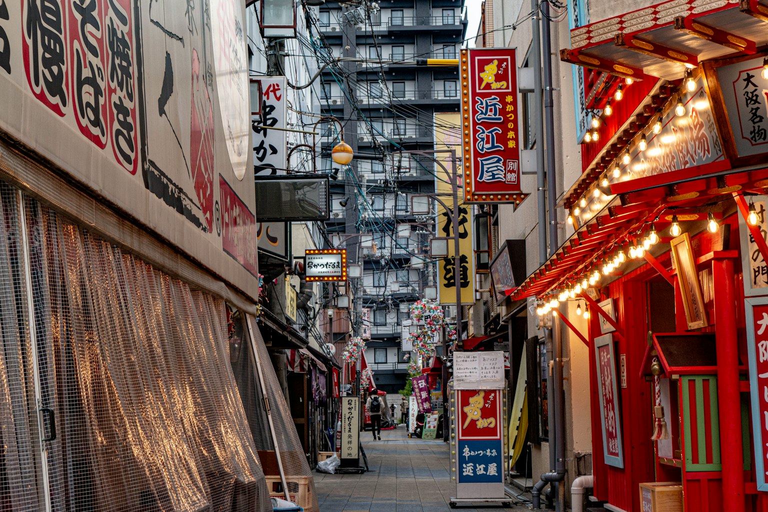 Schmale Gasse mit Restaurants und hellen Schildern