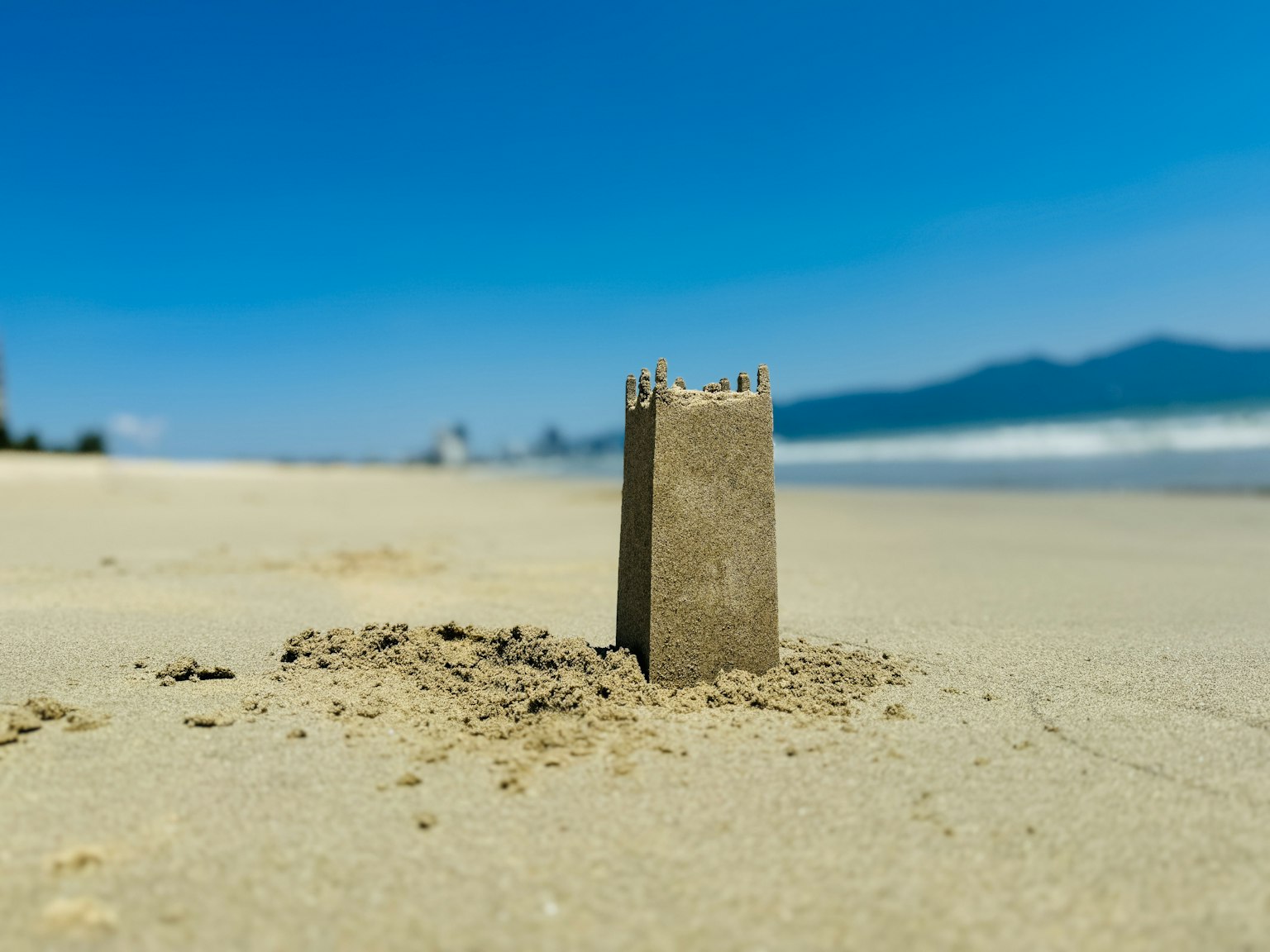 Château de sable sur la plage sous un ciel bleu clair