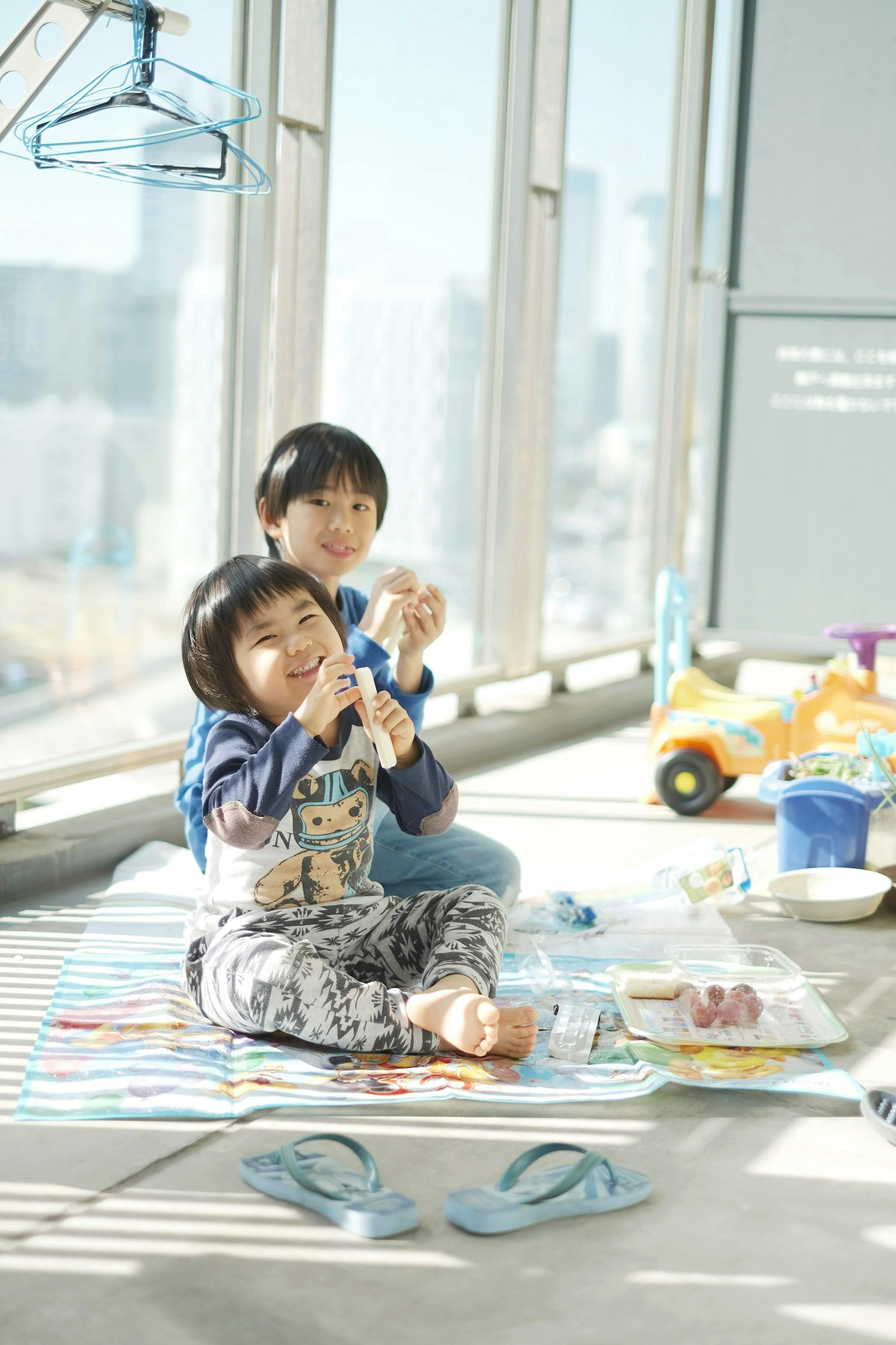 子供たちが窓の近くで遊んでいる様子 食べ物を持って楽しんでいる