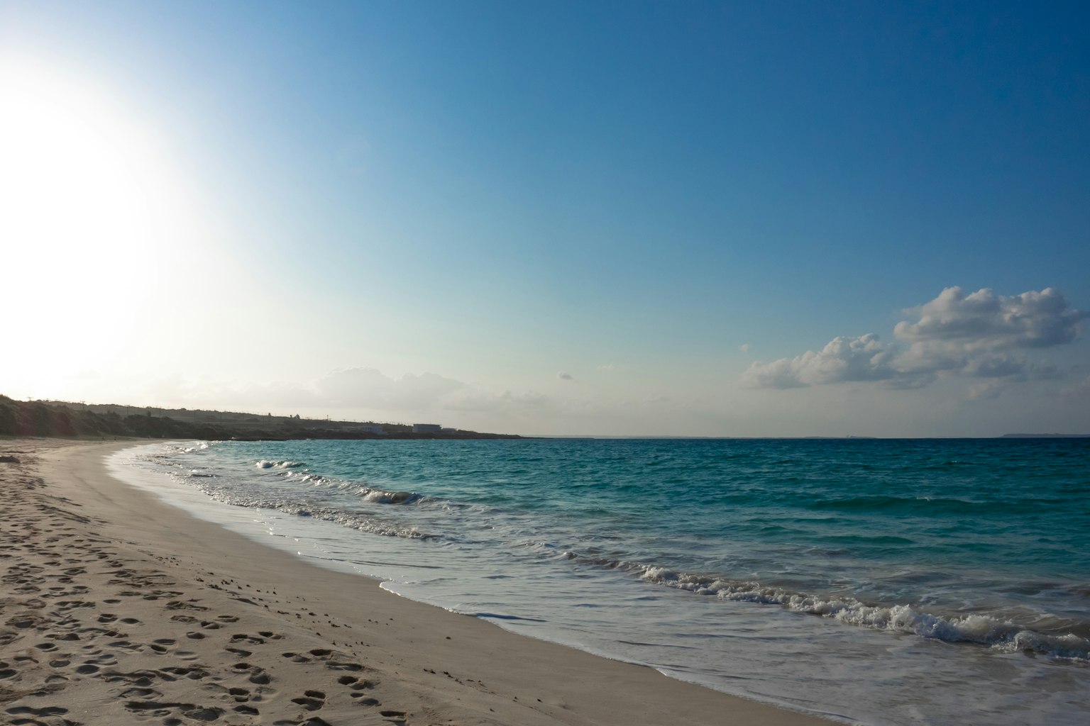 Vista panoramica di un oceano blu e di una spiaggia di sabbia bianca con luce solare