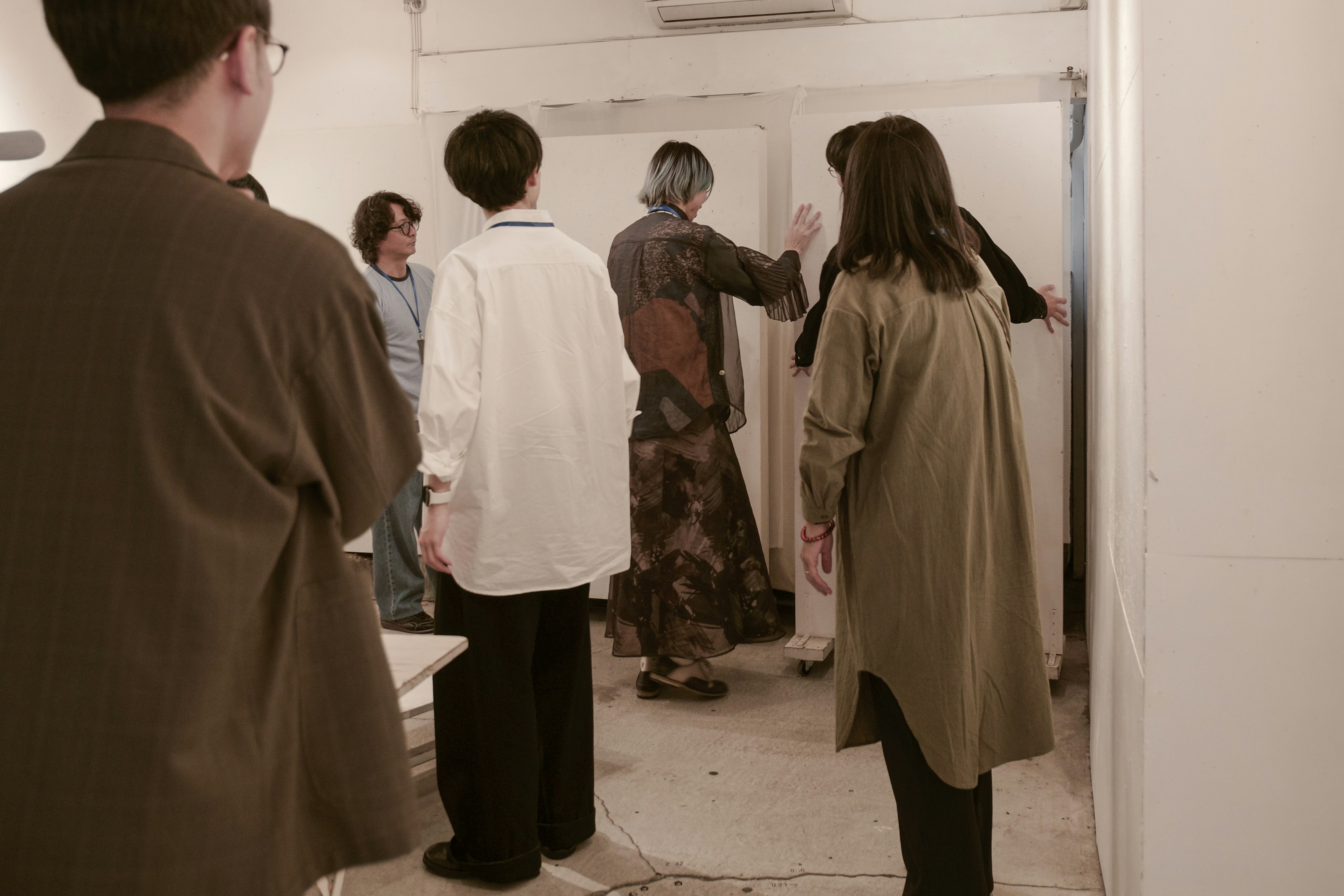 Orang-orang menyesuaikan dinding saat persiapan acara di lorong venue Asakusabashi, Tokyo