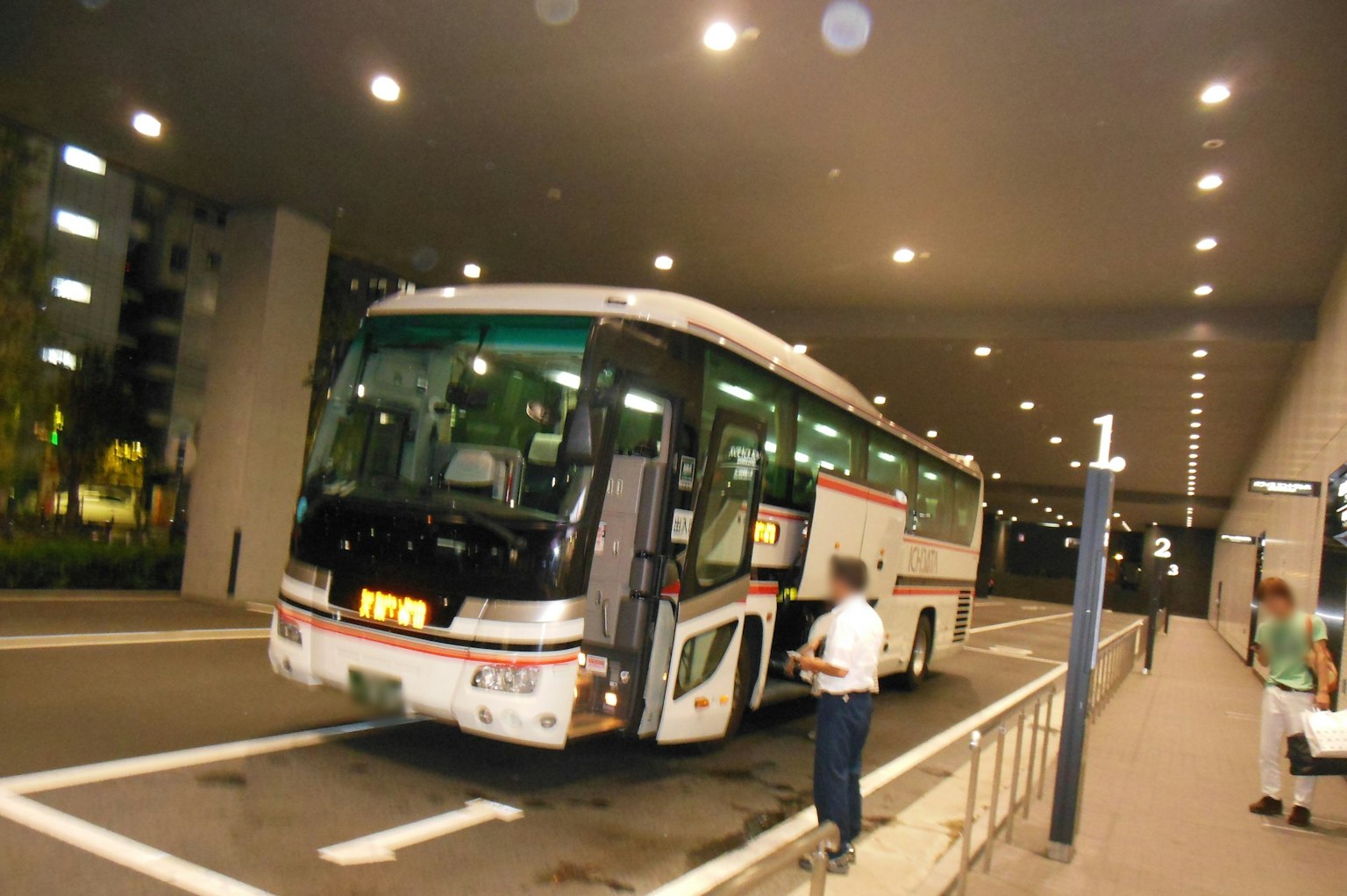 Gran autobús estacionado en una parada de autobús del aeropuerto con pasajeros
