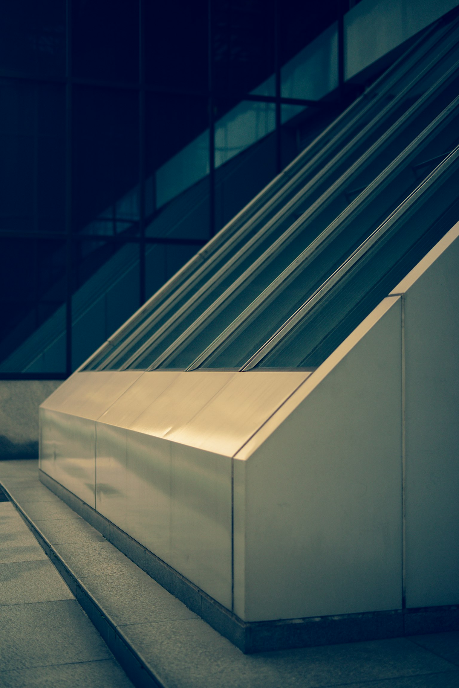 Neigungen aus Metall mit Glaswand, die moderne Architektur widerspiegelt