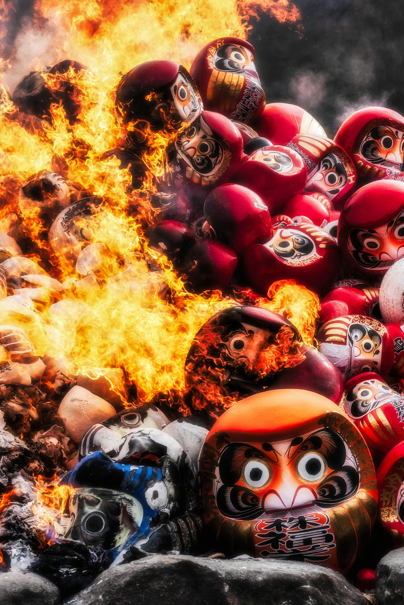 Un tas de poupées Daruma au milieu de flammes rugissantes