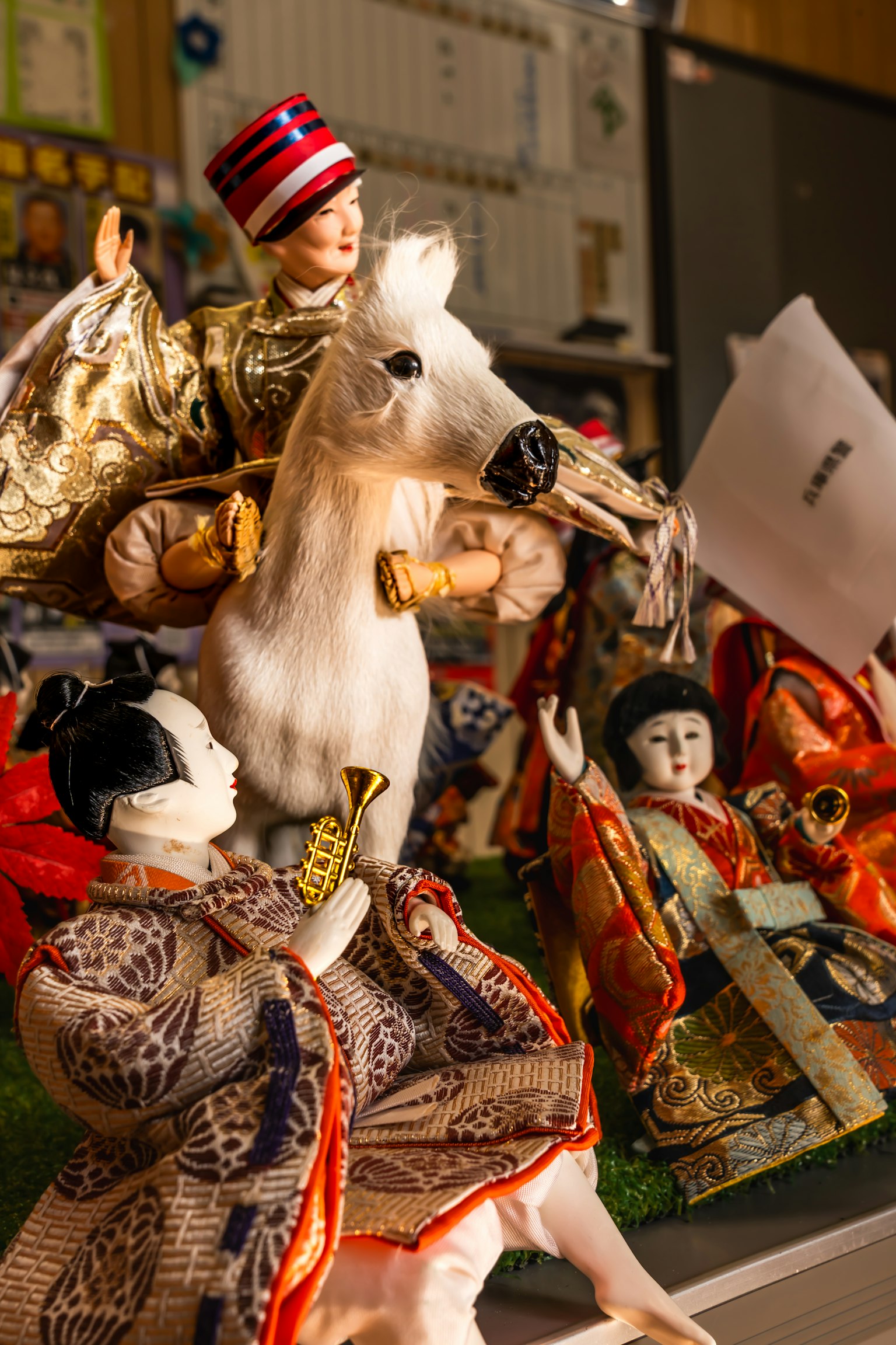 Dekorative Puppen, darunter ein Reiter auf einem weißen Pferd und Figuren in traditioneller Kleidung