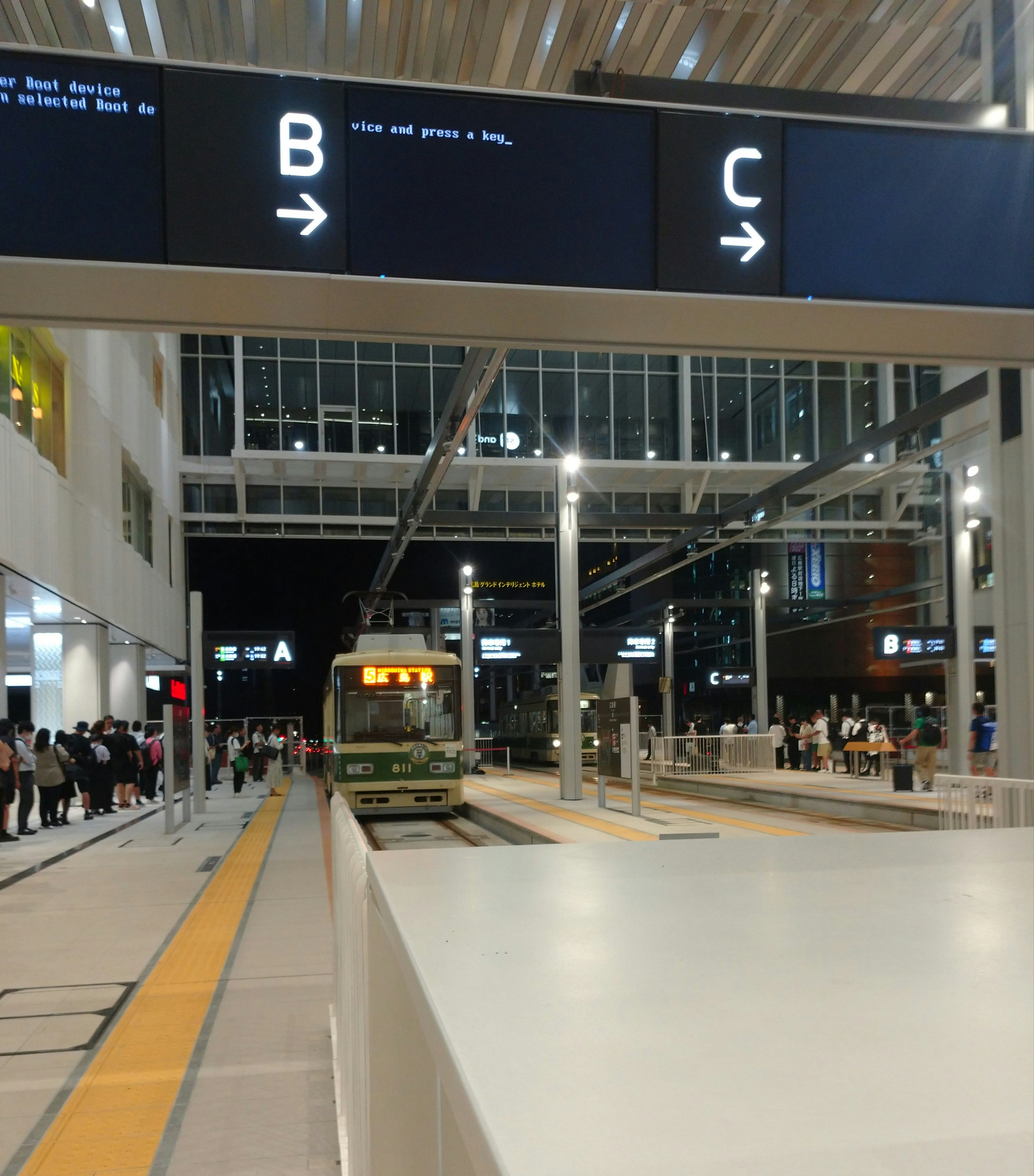 屋内の駅構内で路面電車が停車する風景