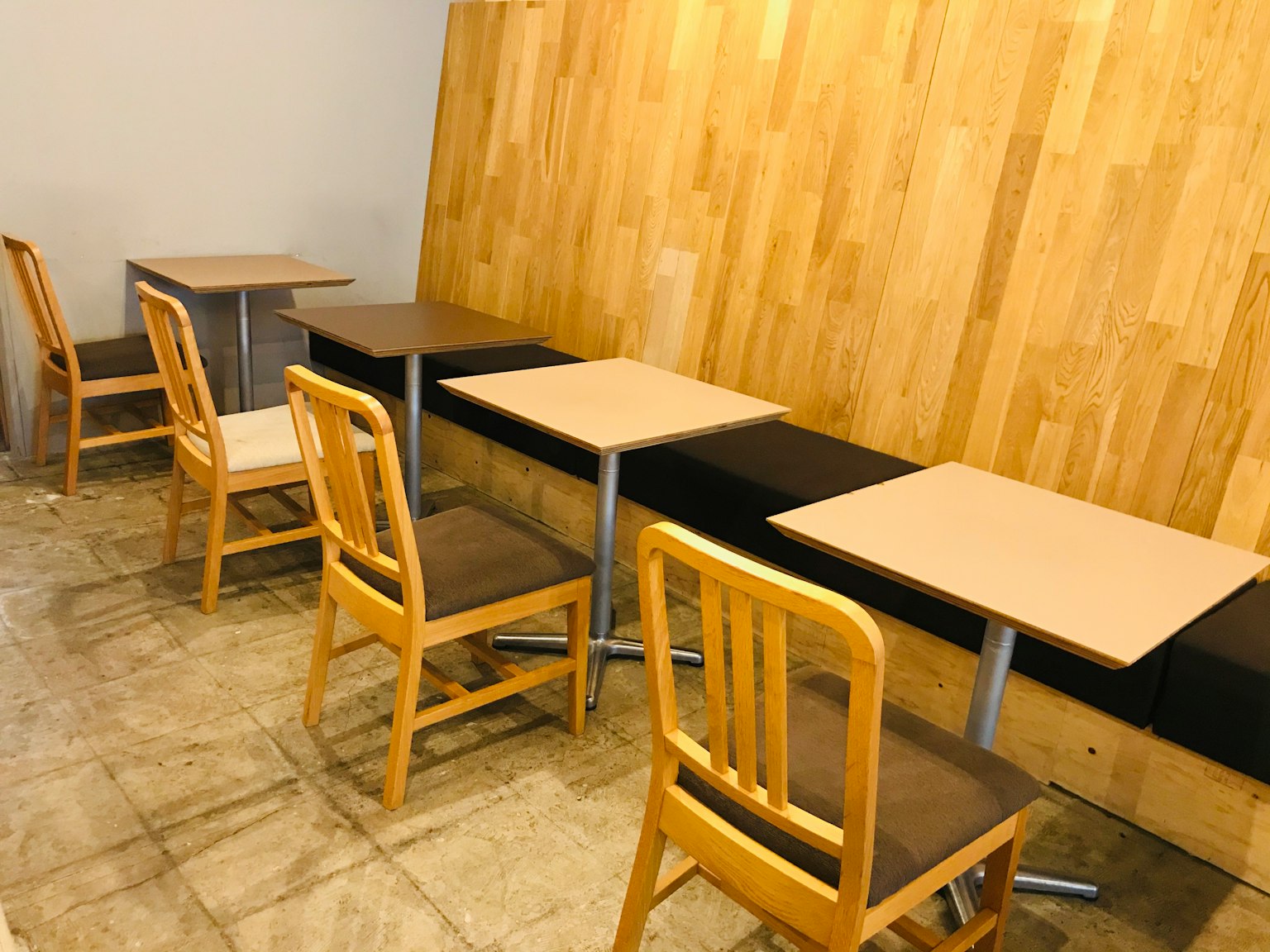 Vue intérieure d'un café avec un mur en bois et des tables
