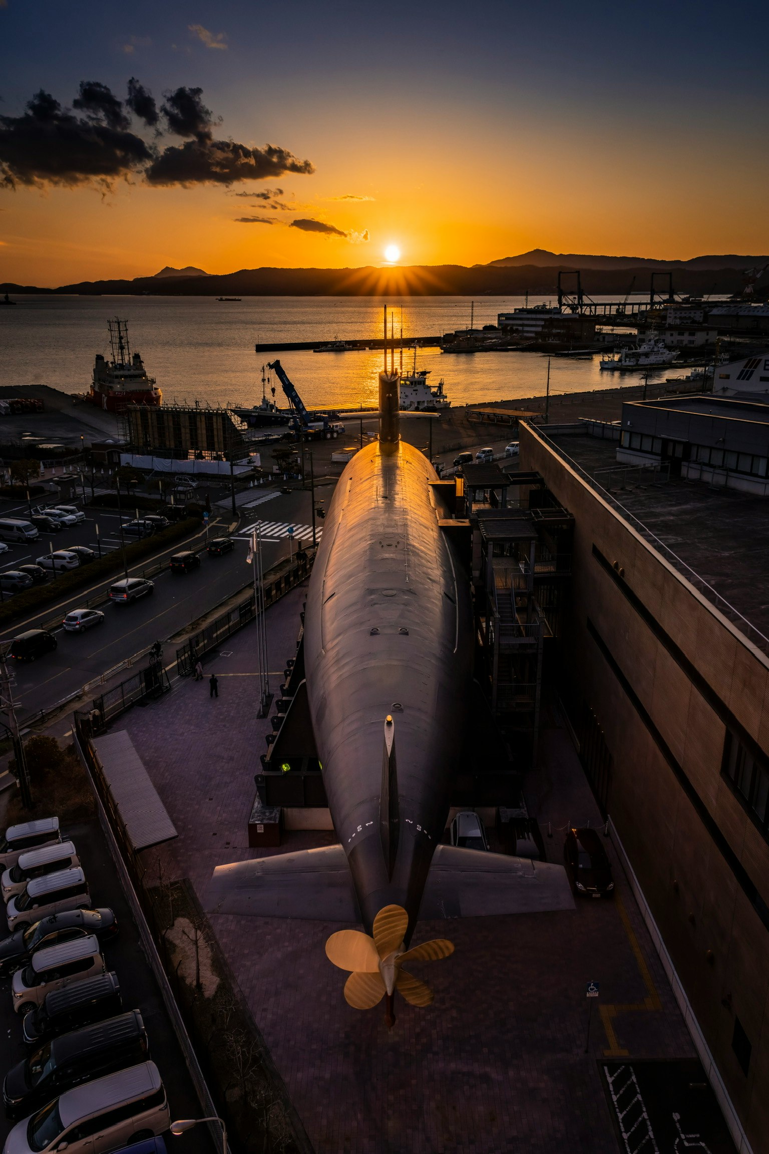 夕焼けの海に浮かぶ潜水艦と港の桟橋