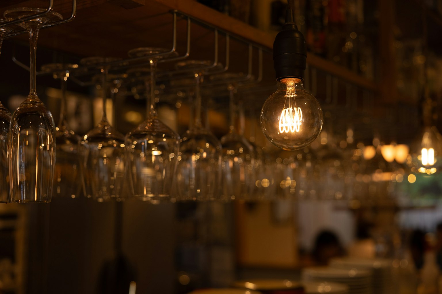 Bicchieri appesi e lampadina calda in un bar