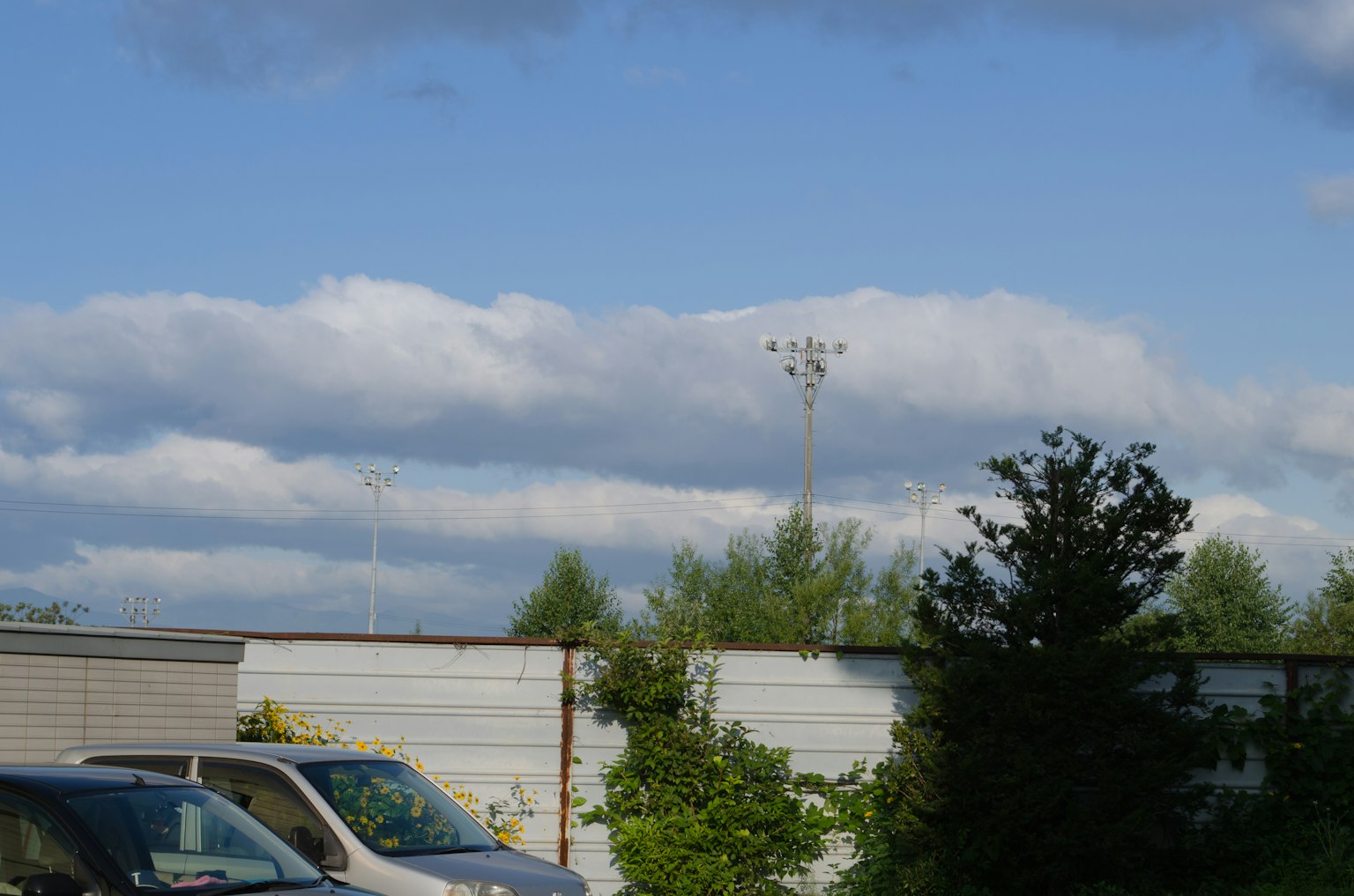 Industrielandschaft mit weißen Wolken und blauem Himmel mit Bäumen