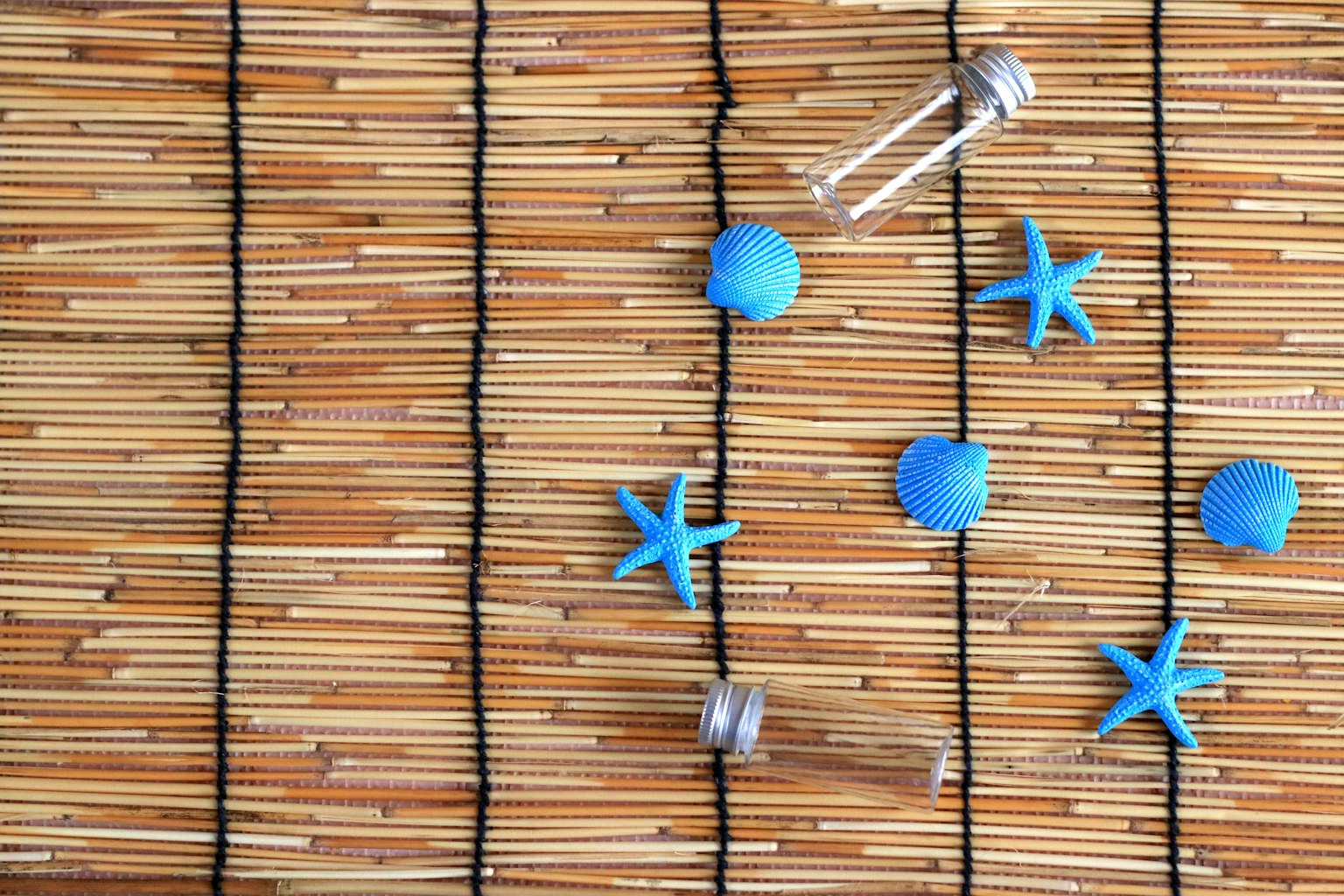 Estrellas y esferas azules dispuestas sobre una estera de bambú