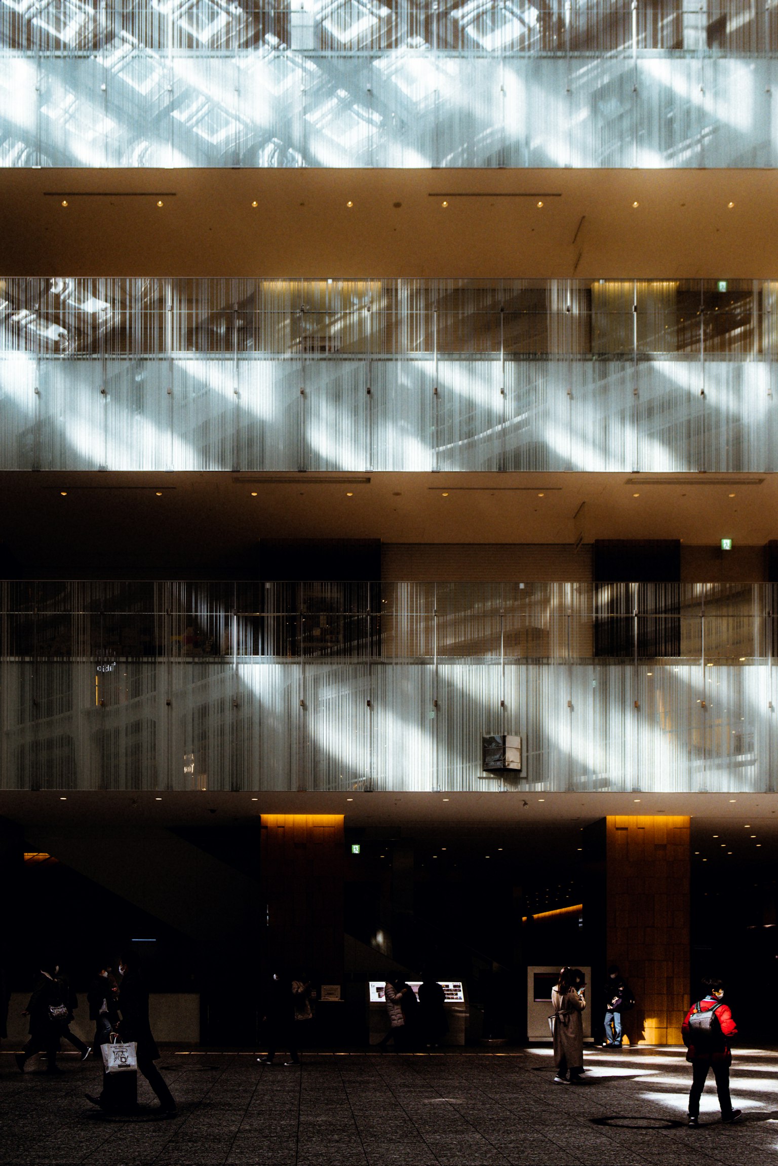 Intérieur d'un bâtiment moderne avec des motifs de lumière et des personnes