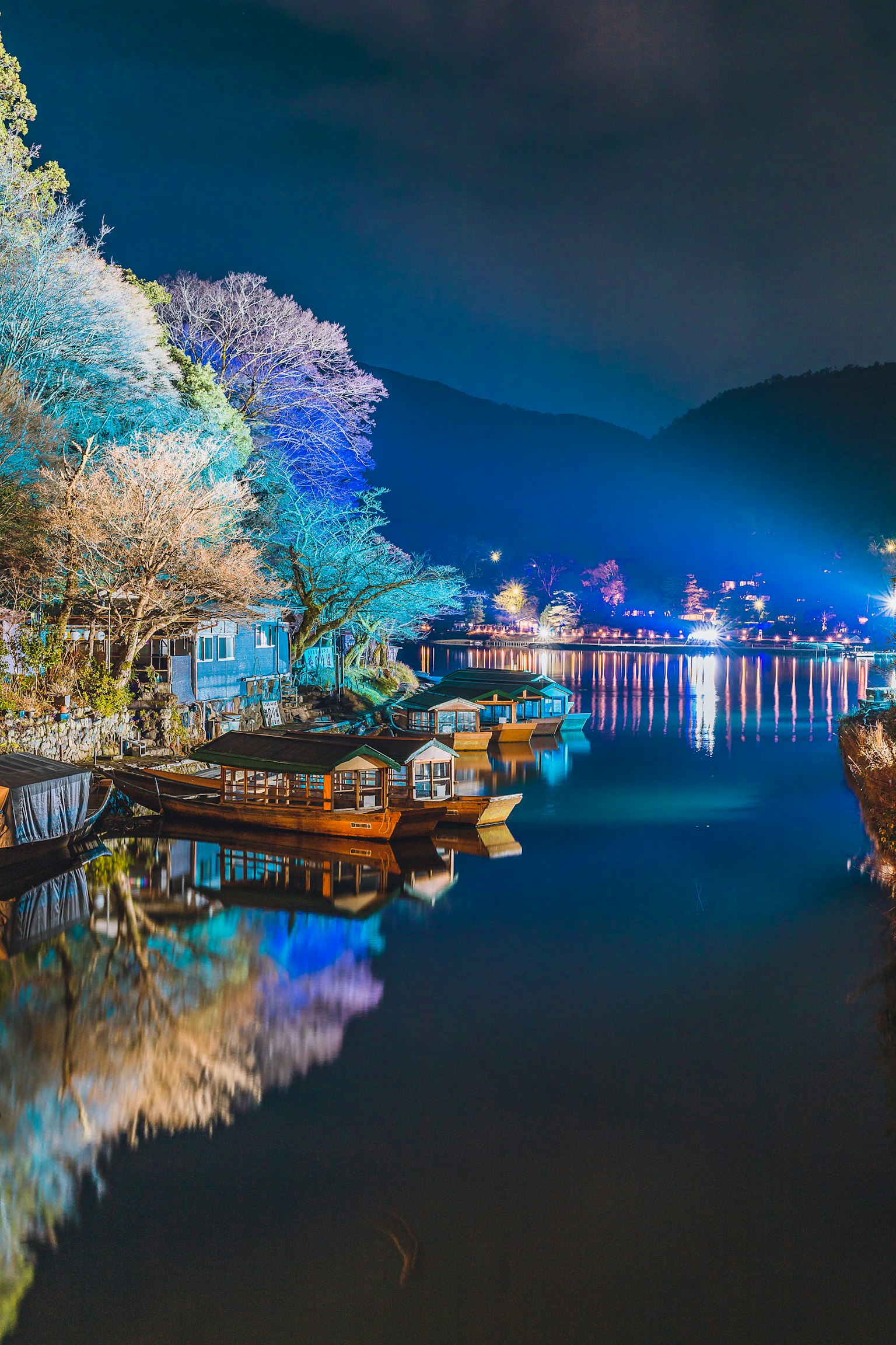 Lac nocturne serein avec de belles réflexions des bateaux et des arbres