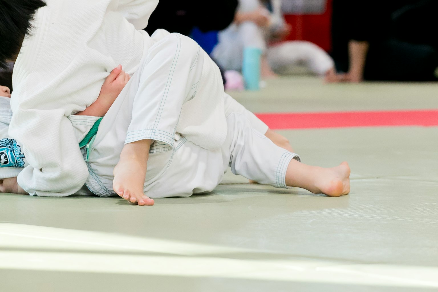 Primo piano dei piedi di bambini durante un incontro di judo
