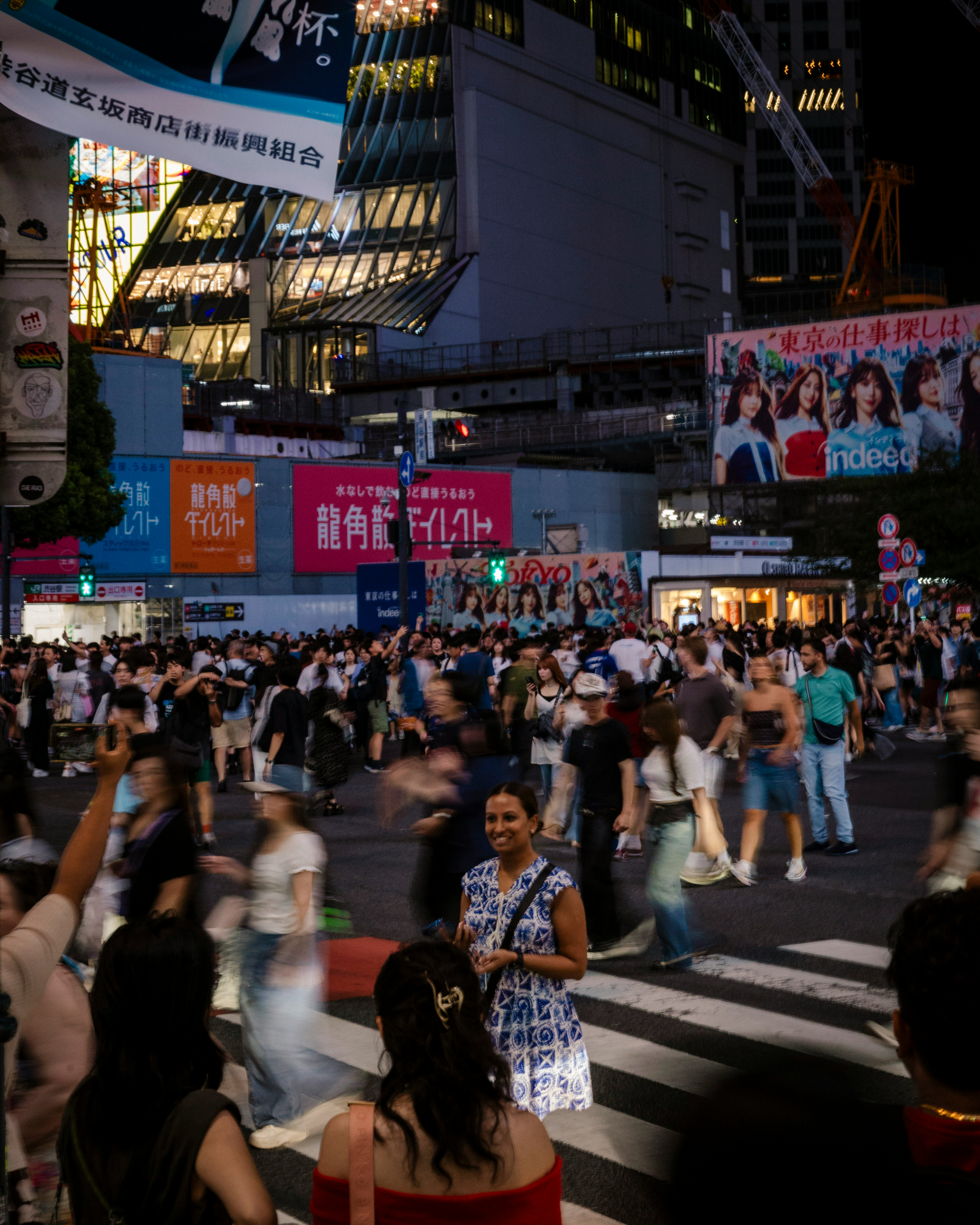 繁華街の横断歩道で人々が行き交う夜の街並み