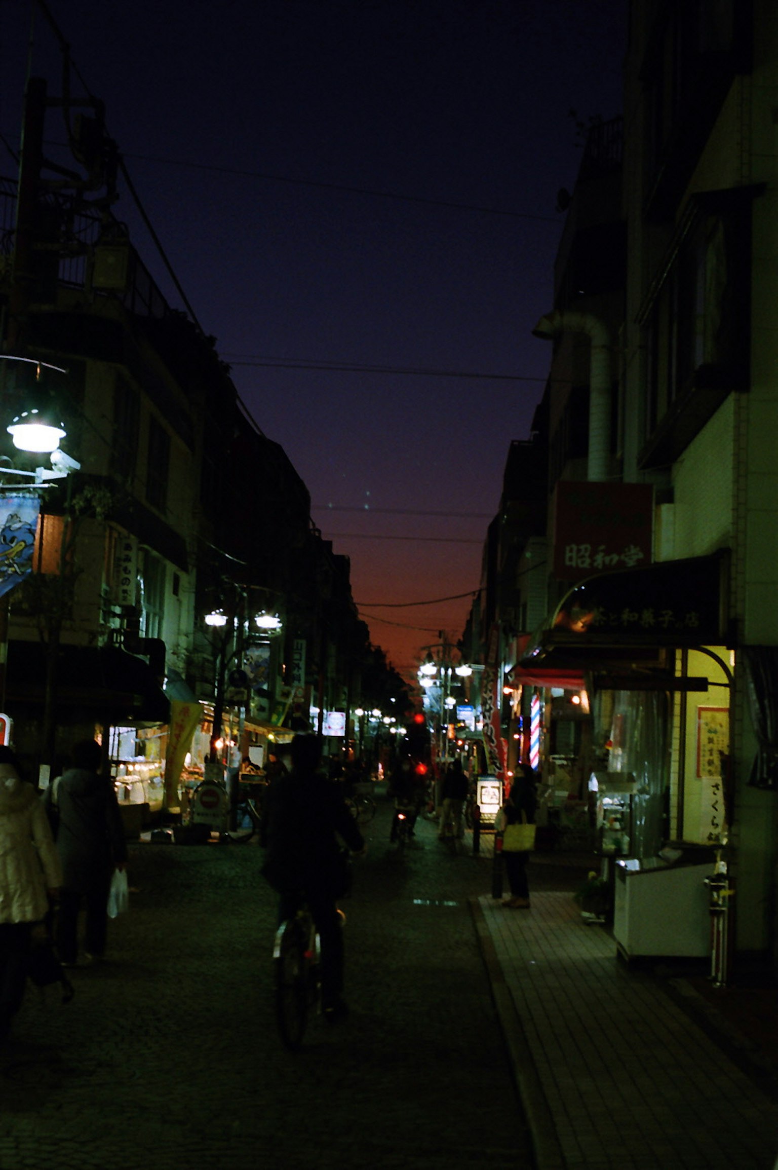 Night street scene with people and motorcycles colorful neon signs illuminating the area