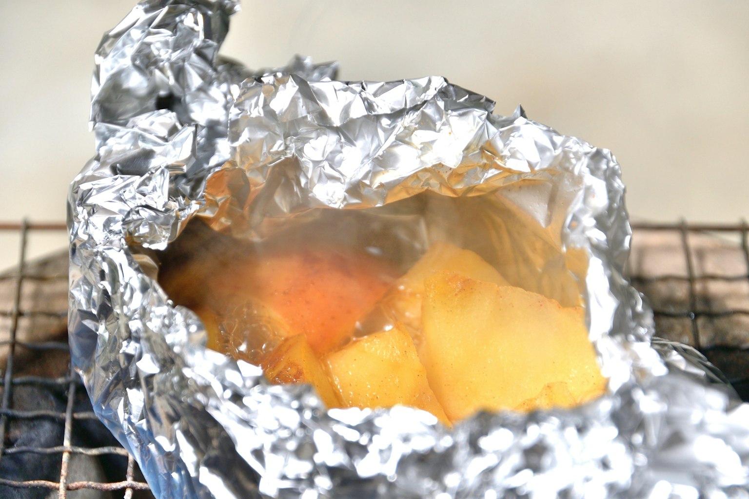 Steamed food wrapped in aluminum foil with visible steam