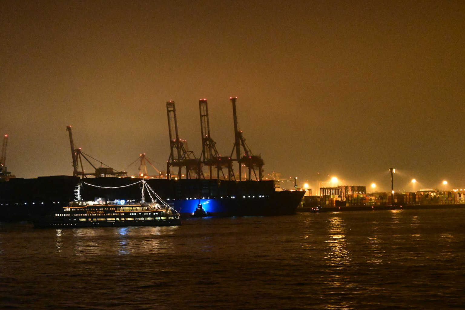 Scena notturna di una nave ormeggiata con silhouette di gru