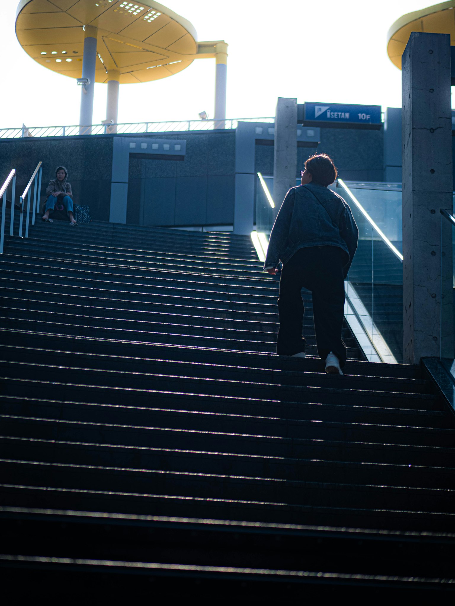 Hình bóng một người đang leo cầu thang với nền sáng