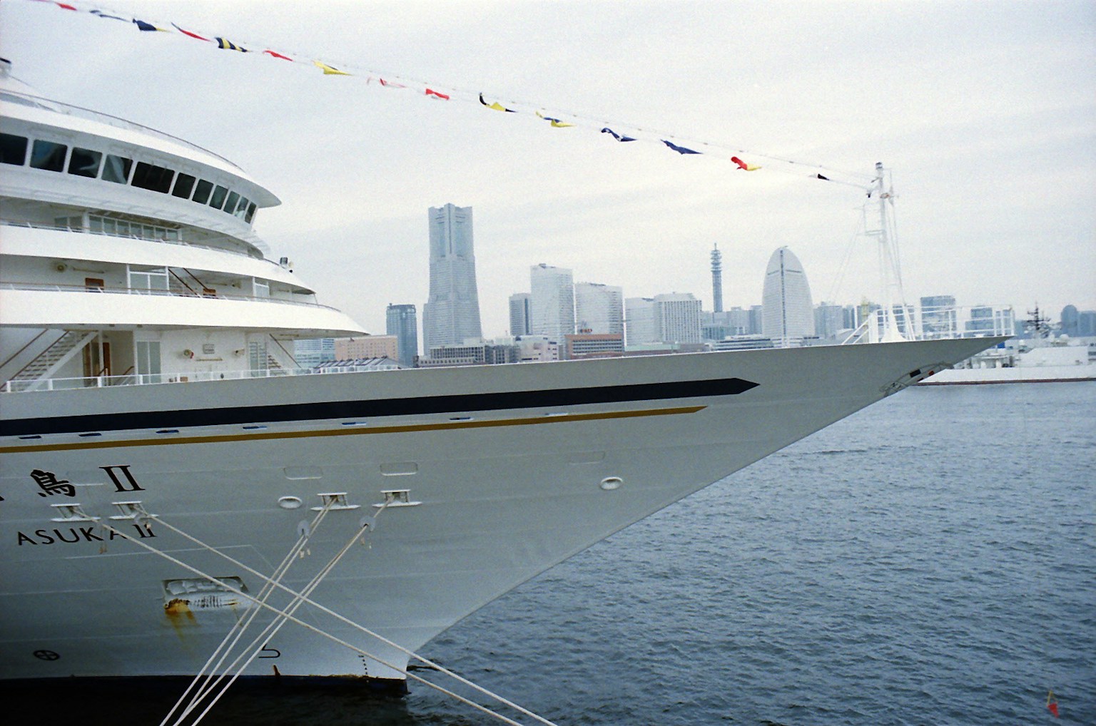 Prow dari kapal pesiar mewah dengan latar belakang cakrawala Yokohama