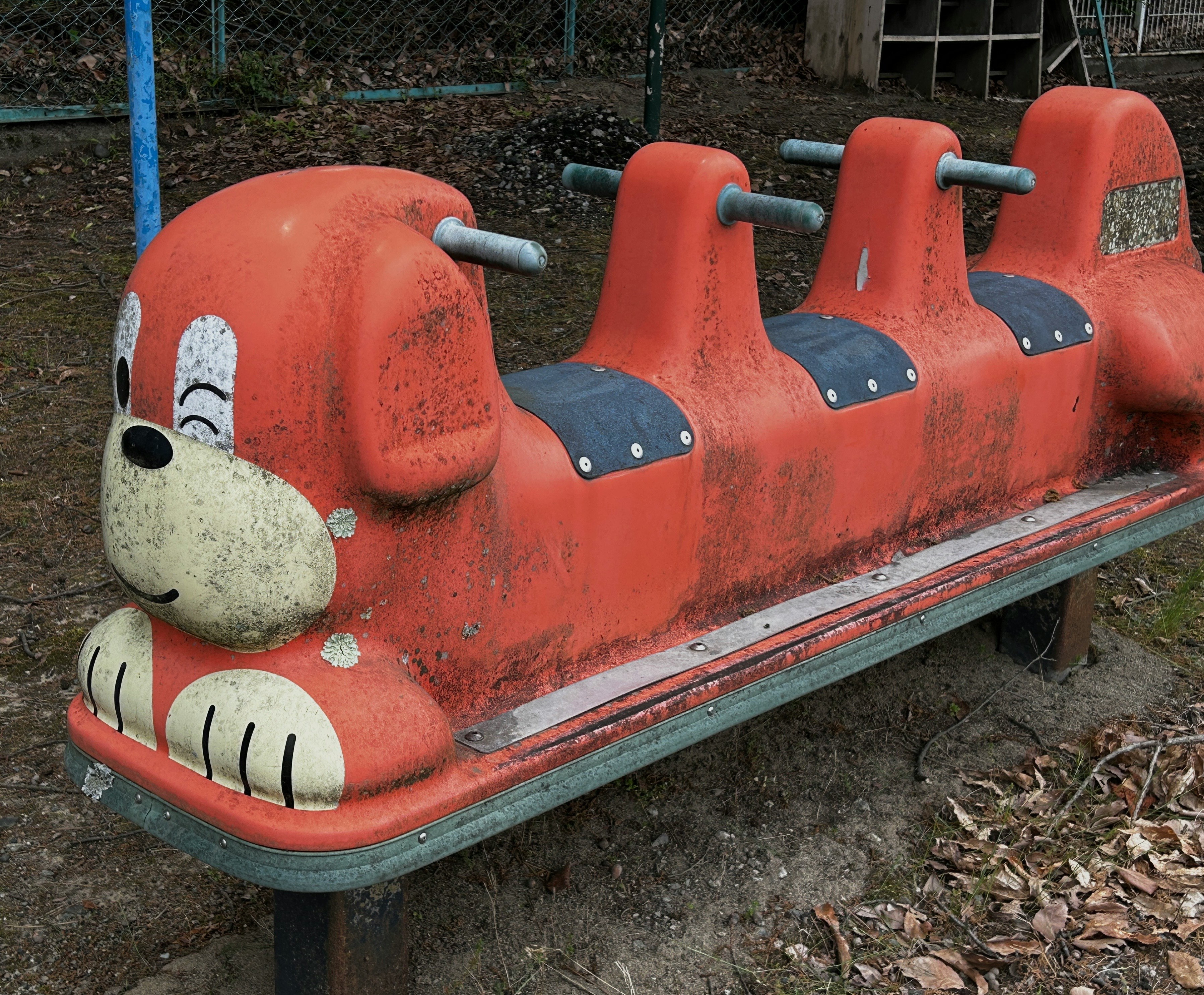 赤いレトロな遊具（公園の放置されたブランコ）