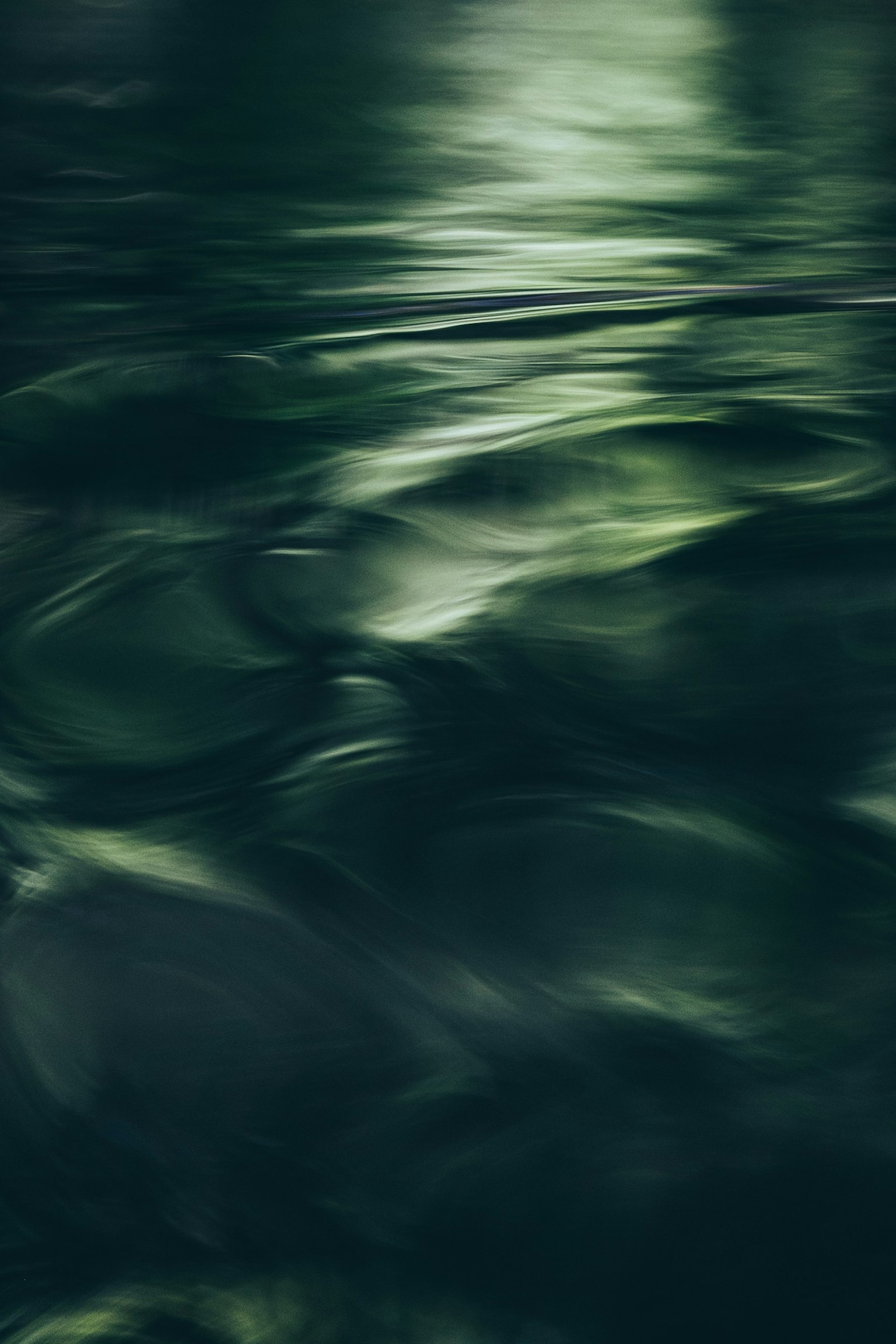 Reflexionen und Wellen auf einer grünlichen Wasseroberfläche