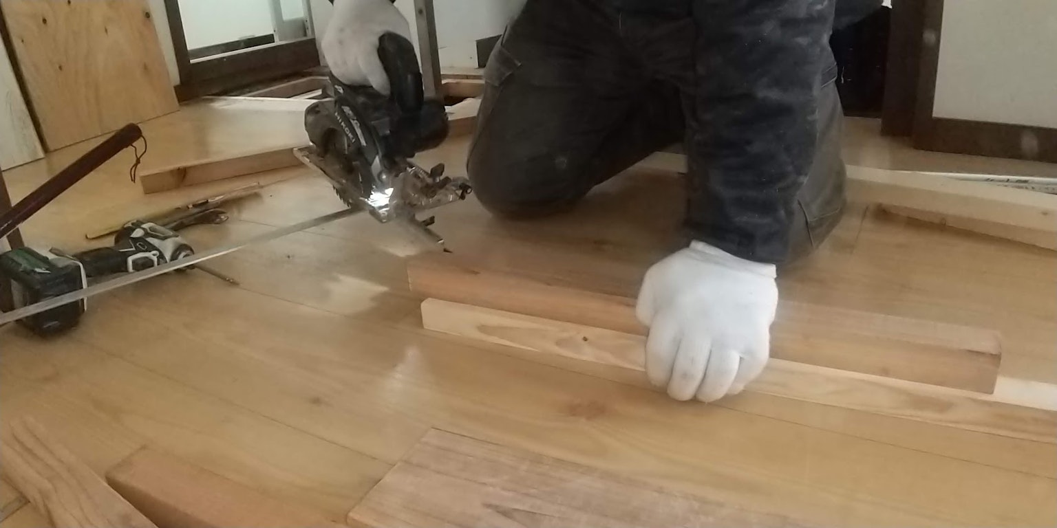 Arbeiter verwendet eine Stichsäge auf Holzplanken