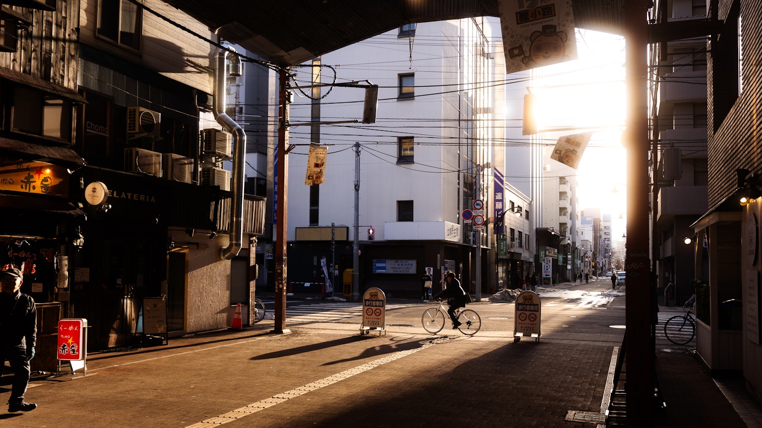 Städtische Straße bei Sonnenuntergang mit Menschen und sanftem Licht