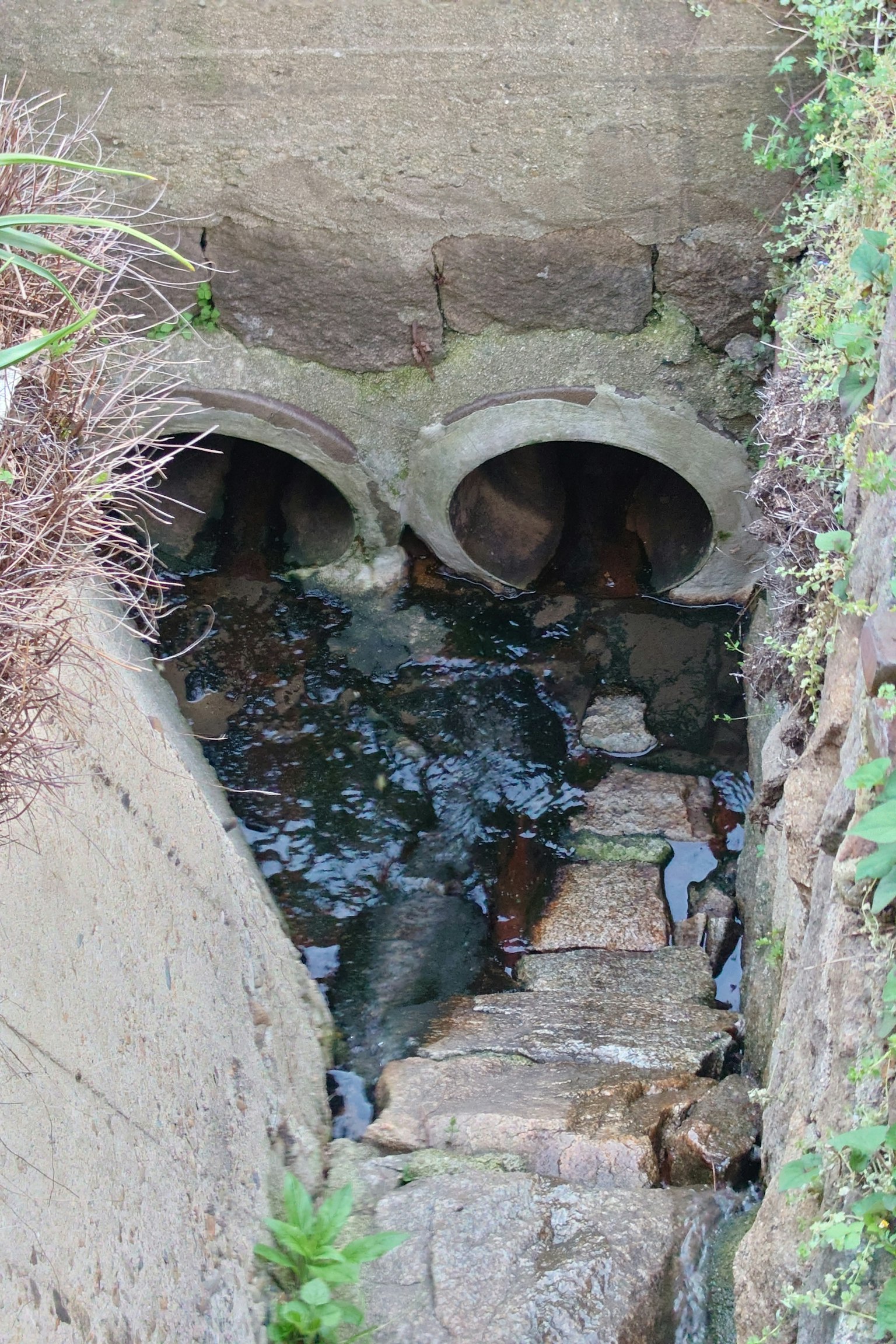排水管開口的視圖，流動的水和石階