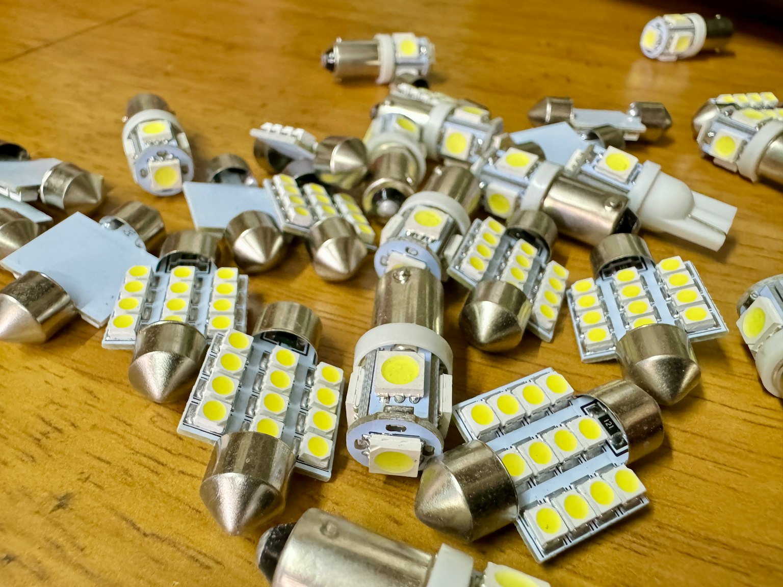 Varias bombillas LED esparcidas sobre una mesa de madera
