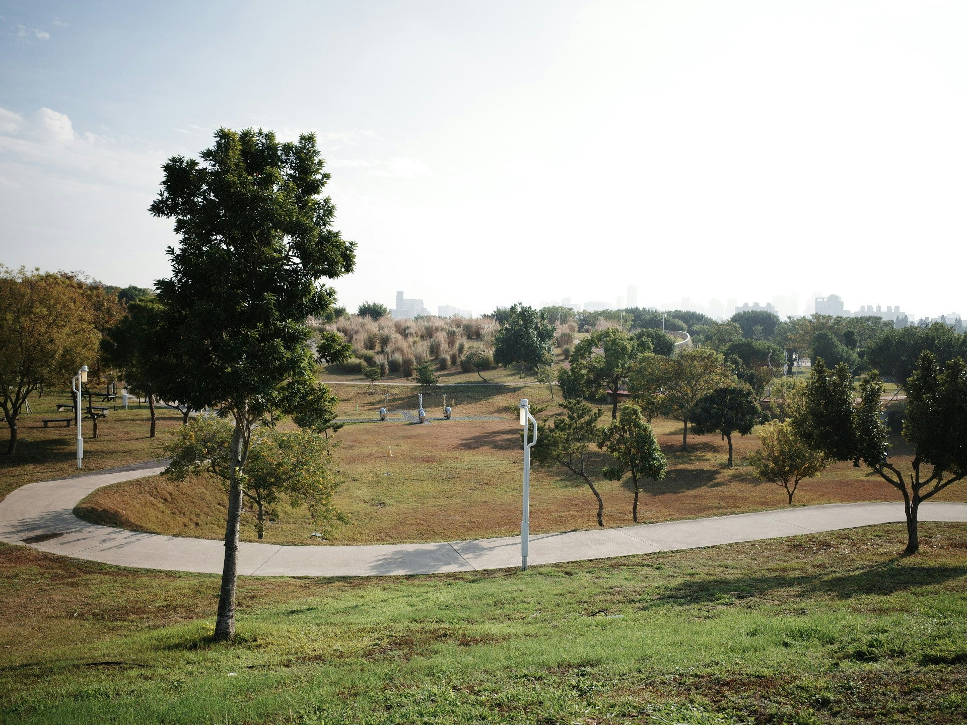 pemandangan taman dengan jalur berkelok dan perbukitan berumput