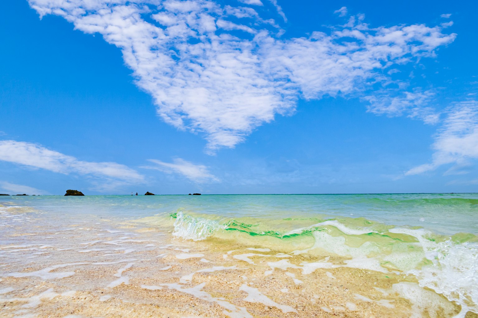 Scena di spiaggia con cielo blu e nuvole bianche acqua chiara e onde dolci