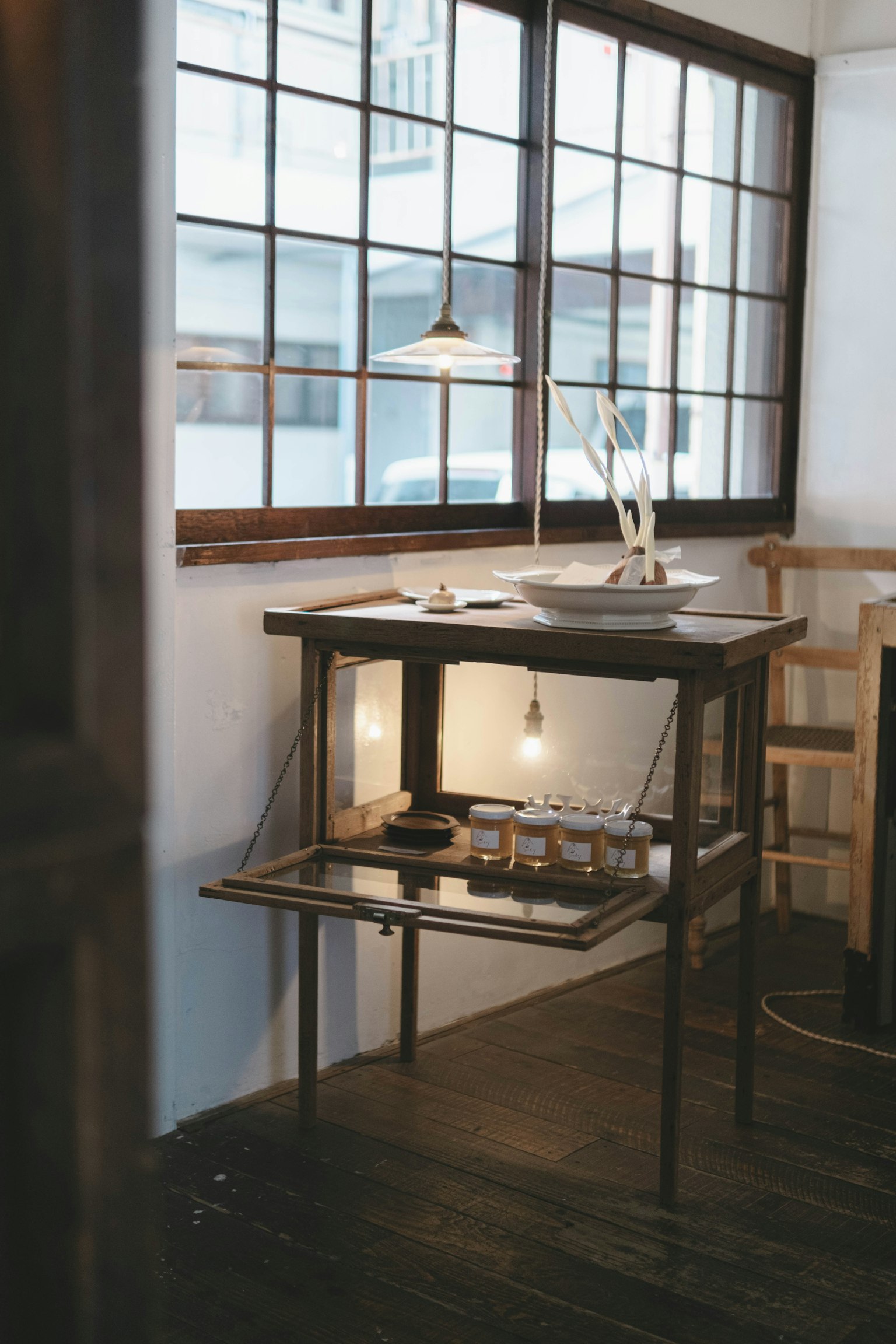 Una mesa de madera en un entorno interior simple con grandes ventanas