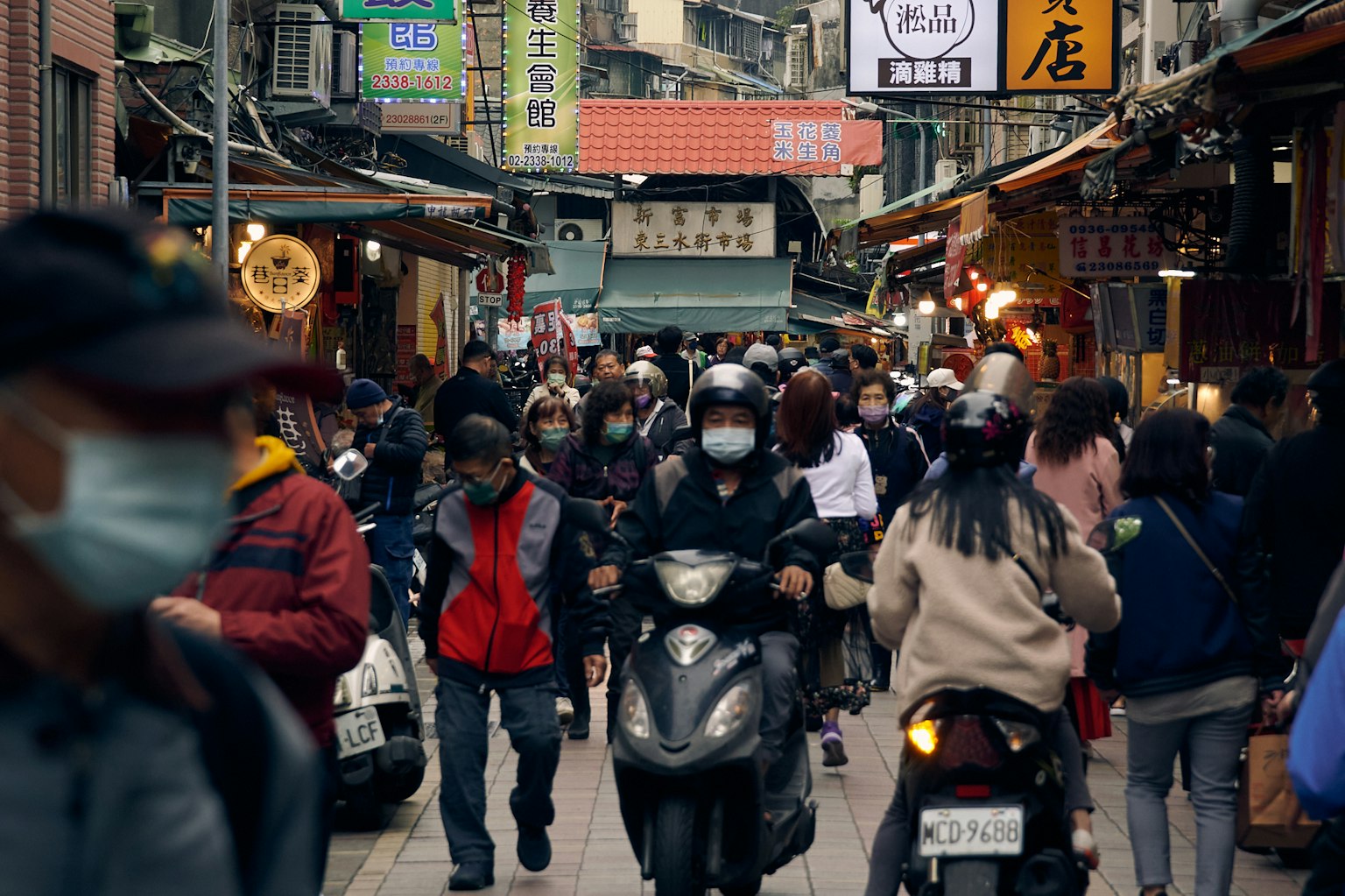 Busy street scene with people and motorcycles