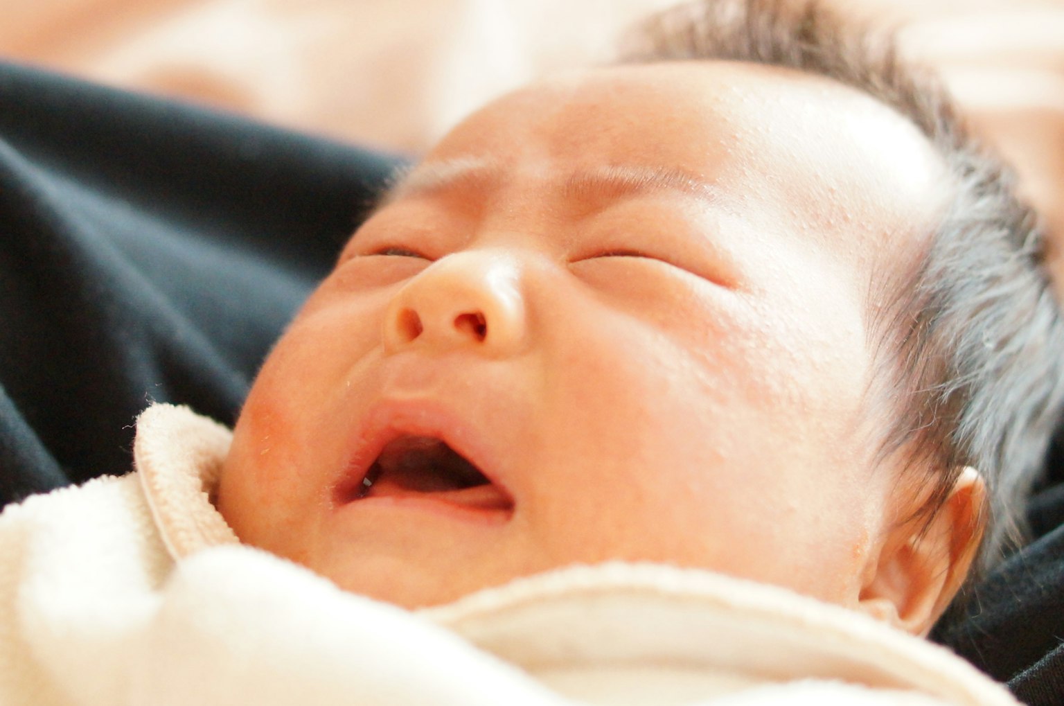 Close-up of a crying baby with a distressed expression