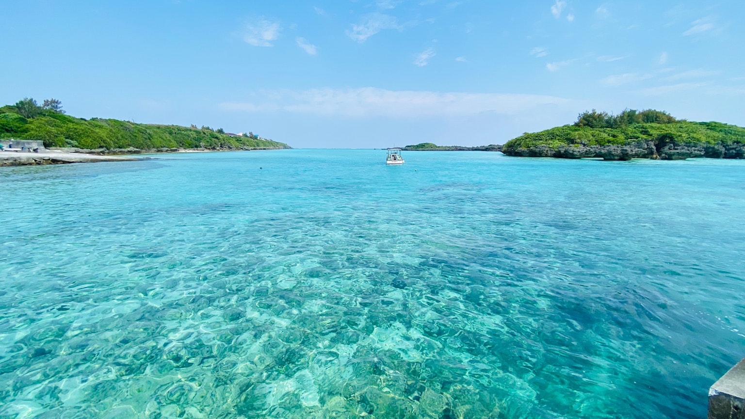 Agua turquesa vibrante con arrecifes de coral visibles e islas distantes
