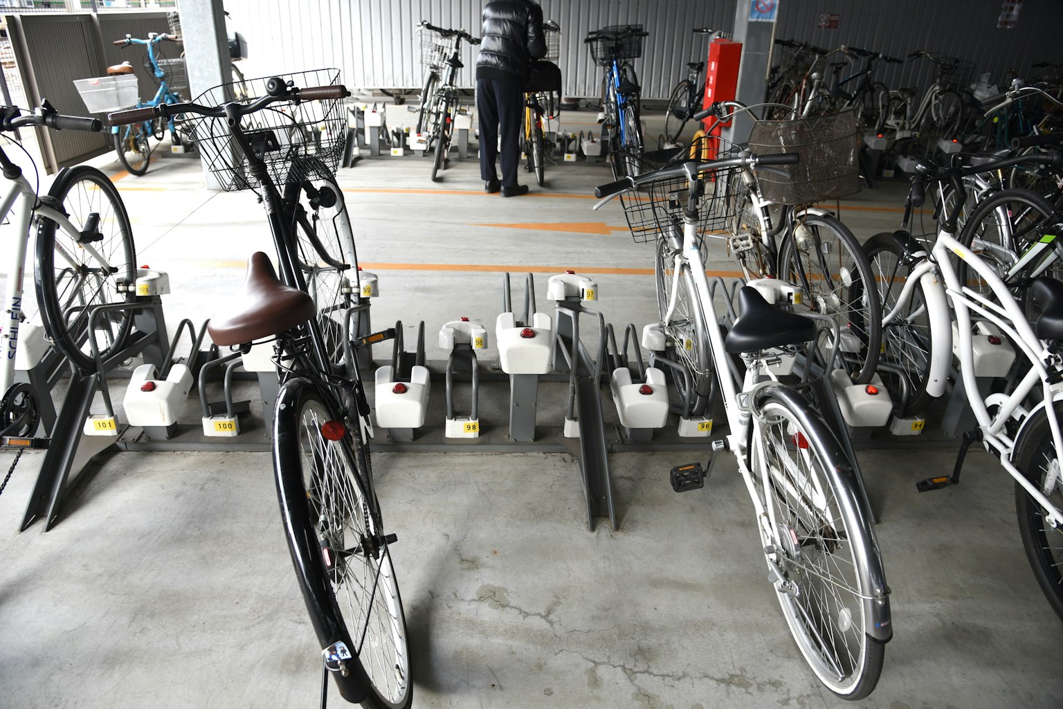 Foto interior de un área de estacionamiento de bicicletas con varias bicicletas