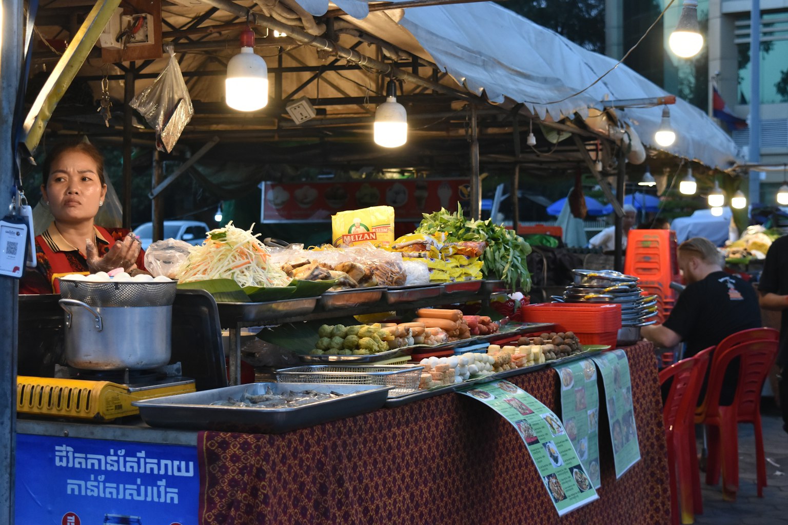 หญิงขายผลิตผลสดที่ตลาดกลางคืนบรรยากาศอาหารริมถนนที่มีชีวิตชีวา