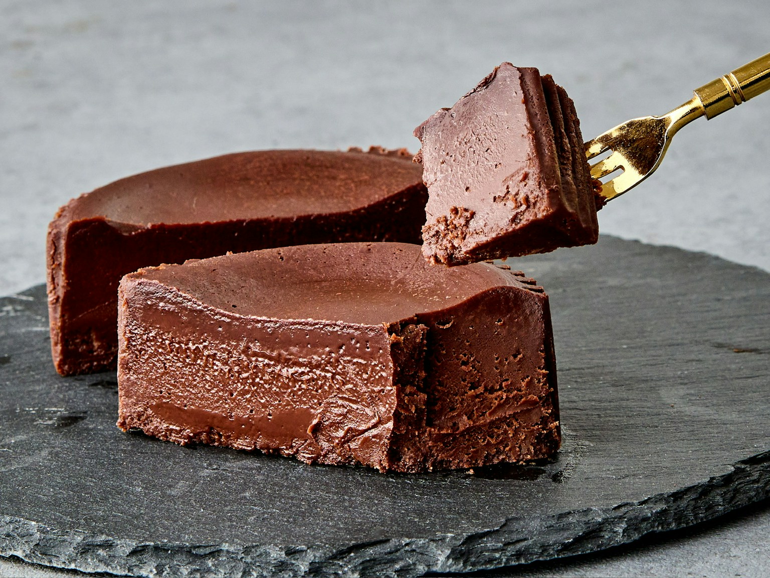 Smooth chocolate cake placed on a slate plate