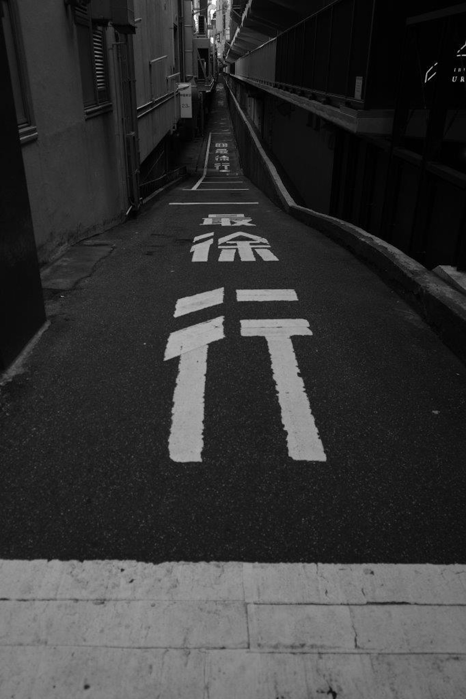Narrow alley featuring white directional markings on pavement