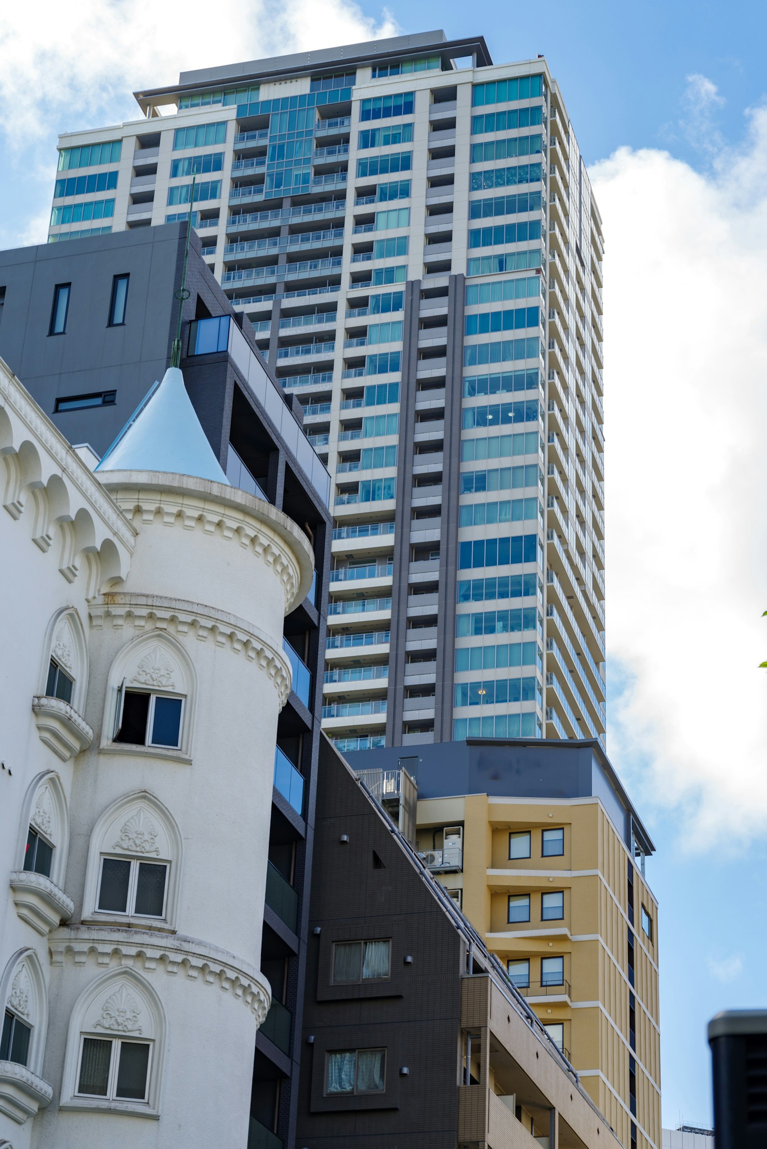 Moderner Wolkenkratzer neben historischer Architektur